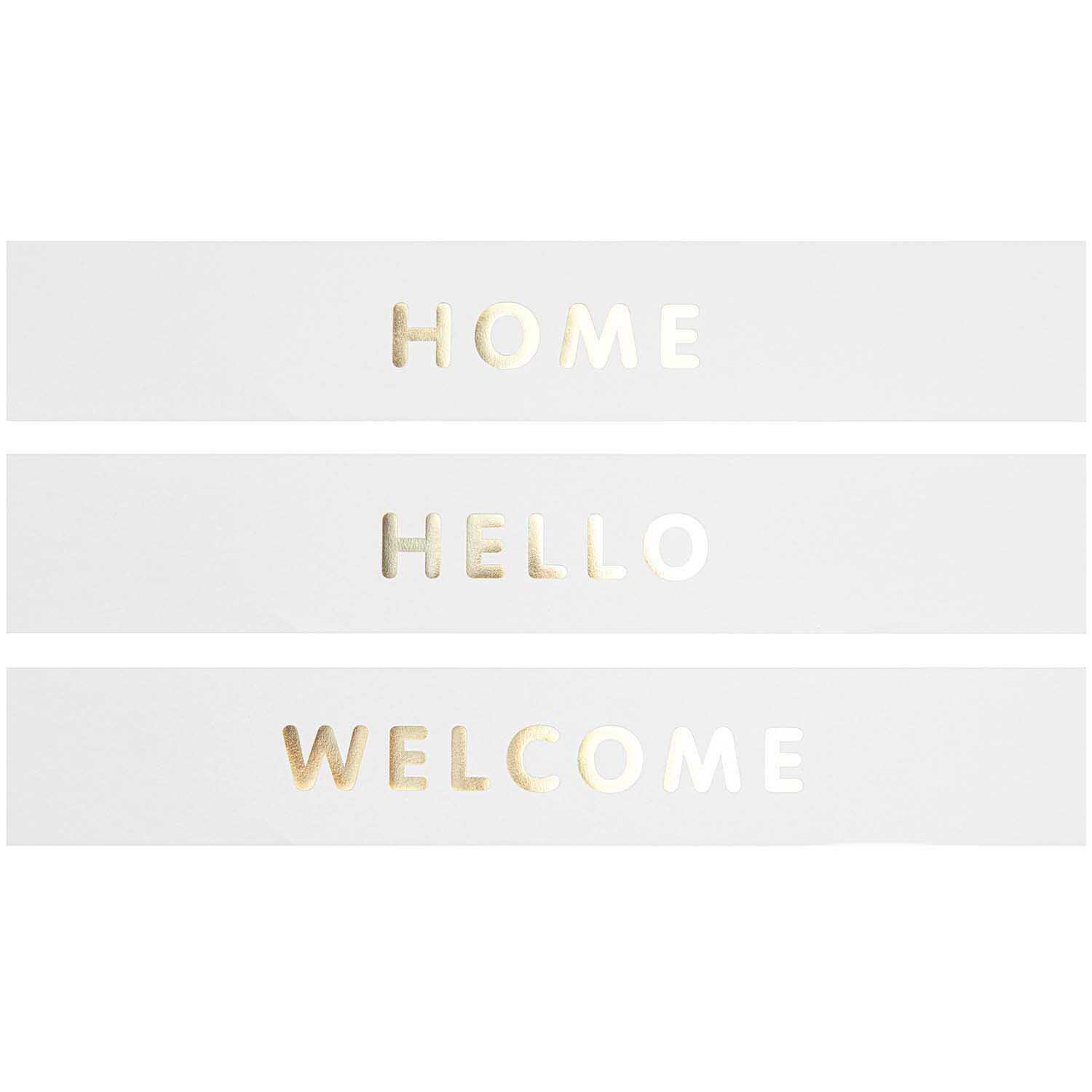 Paper Poetry Papierstreifen mit goldenen Buchstaben "HOME", "HELLO" und "WELCOME" auf weißem Hintergrund.