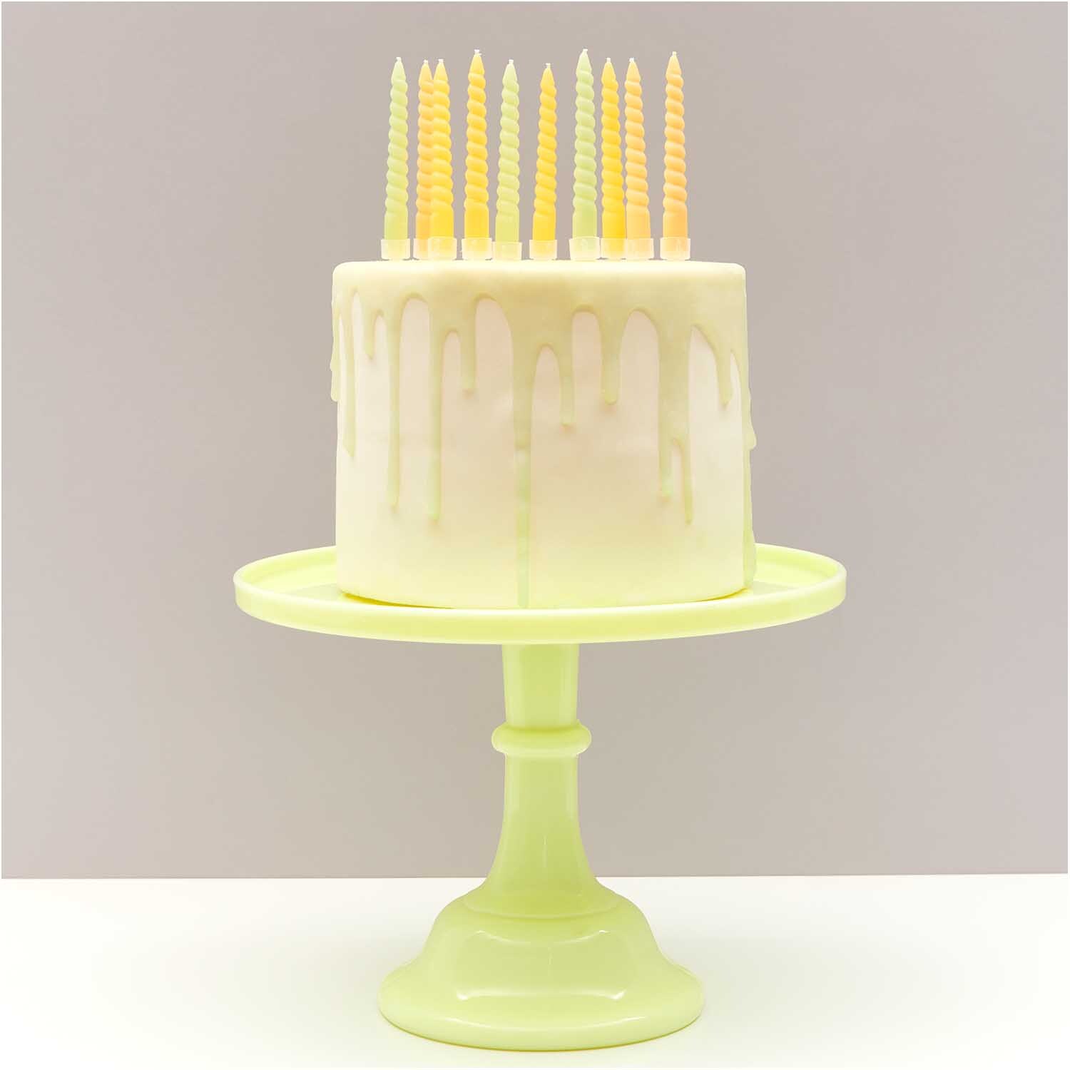 Spiralkerzen smokey gelb Mix 1,2x10cm 10 Stück auf weißem Kuchen mit gelbem Ständer.