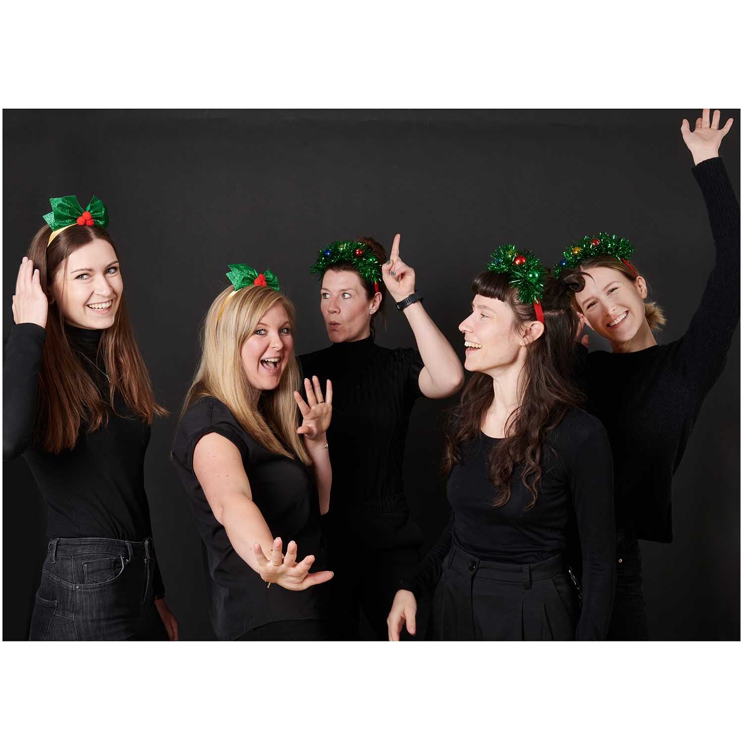 Haarreif Ilex von Rico Design Haarreif Ilex: Fünf lachende Personen tragen festliche Haarreifen mit grünen Blättern und roten Beeren.