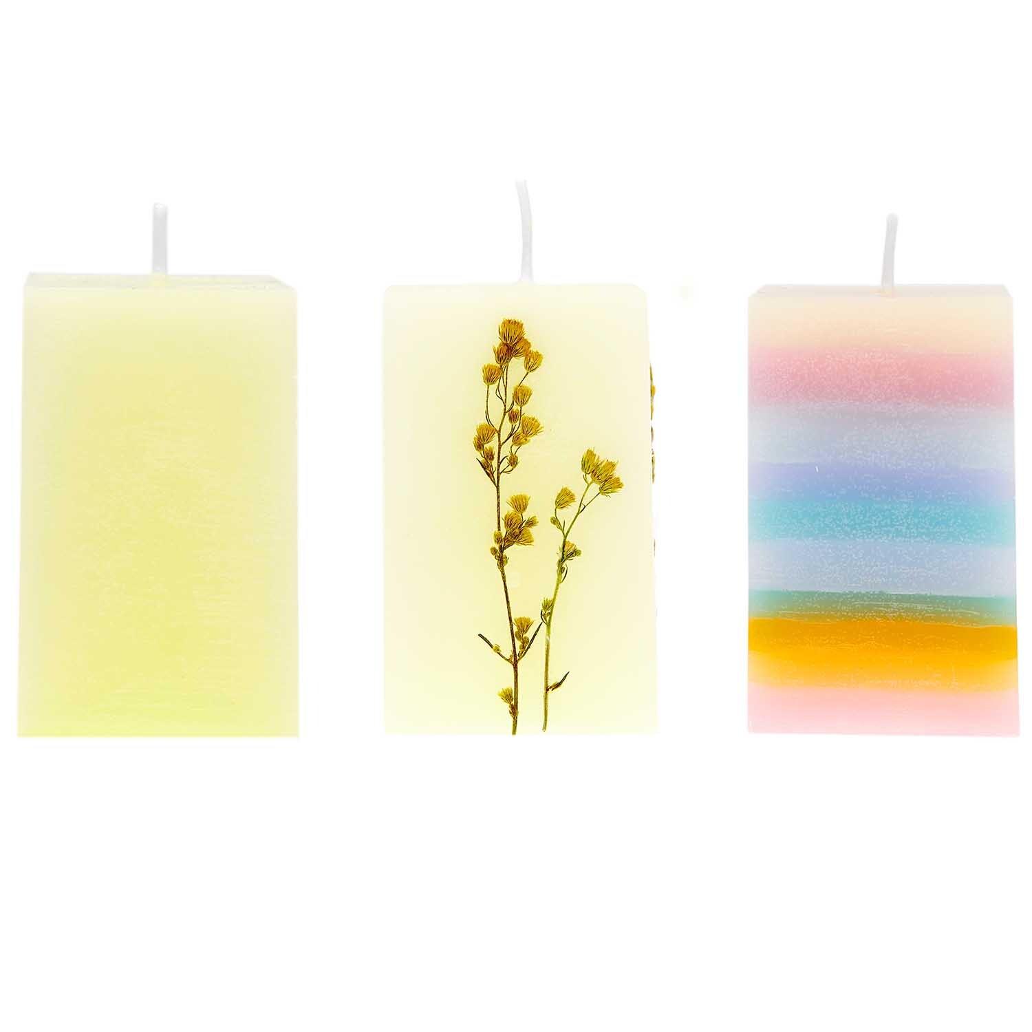 Kerzengießform Quader 61x61x95mm von Rico Design zeigt drei dekorative Kerzen mit Blumen und Regenbogenfarben.