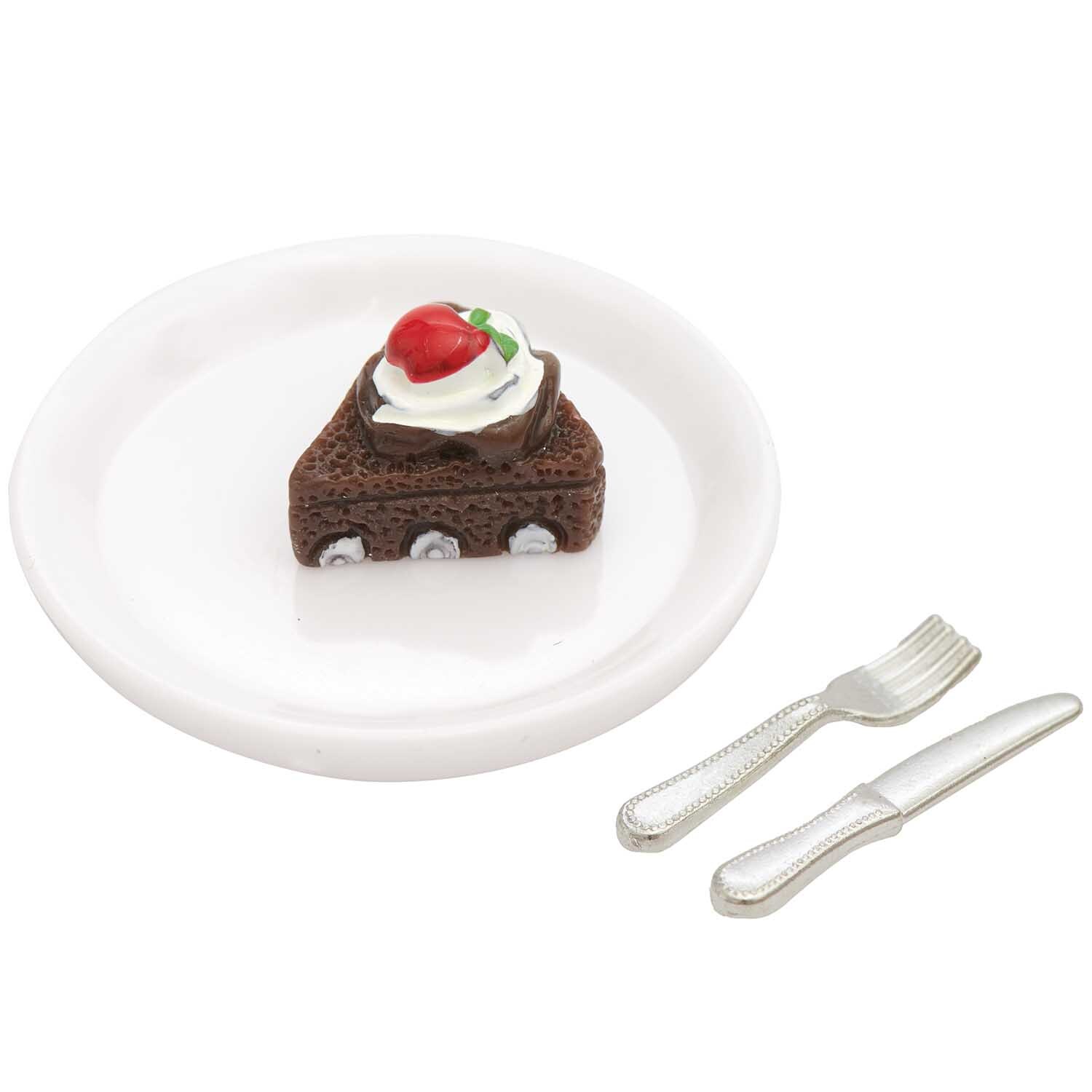 Miniatur Schokotorte auf weißem Teller mit Gabel und Messer, dekoriert mit Sahne und Erdbeere.