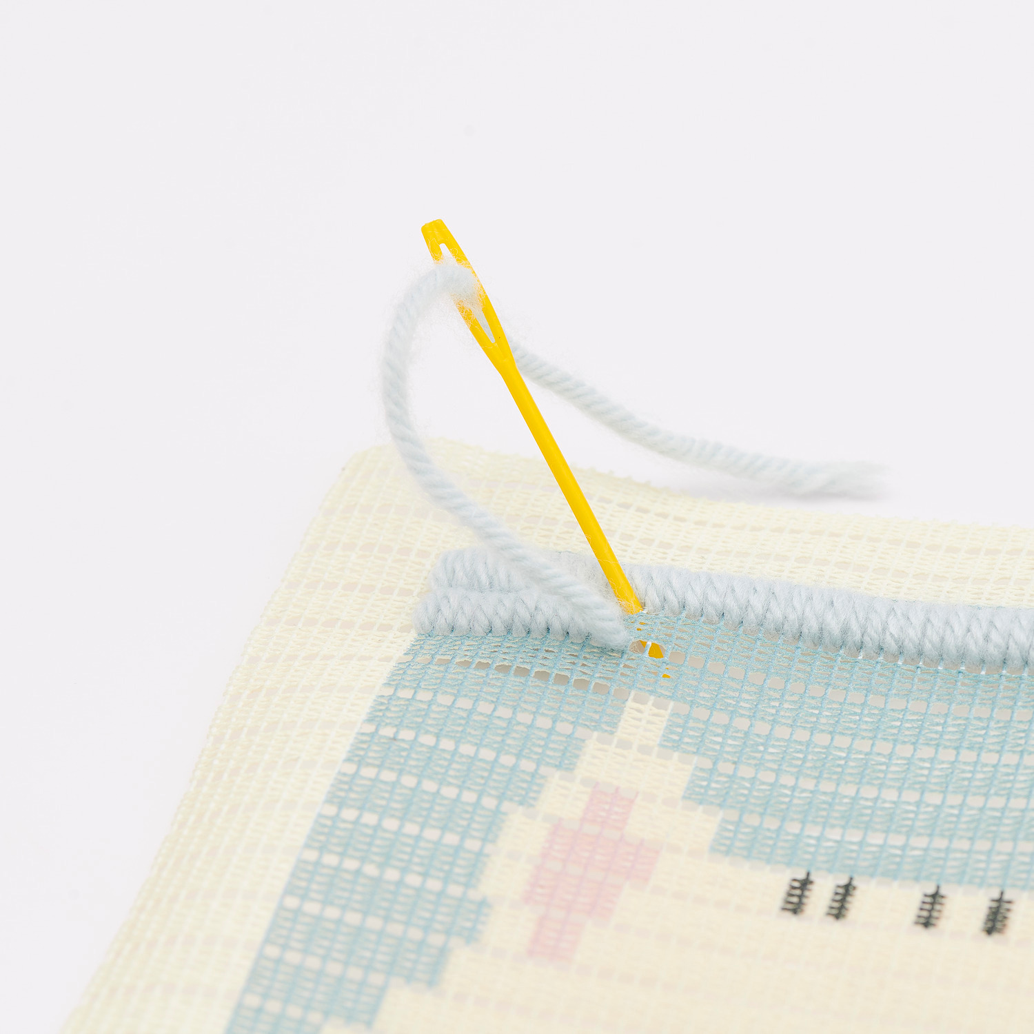 Kit de broderie Longstitch chat 18x30cm from Rico Design Longstitch Stickpackung Katze zeigt eine Nahaufnahme eines Stickprojekts mit Nadel und Faden.