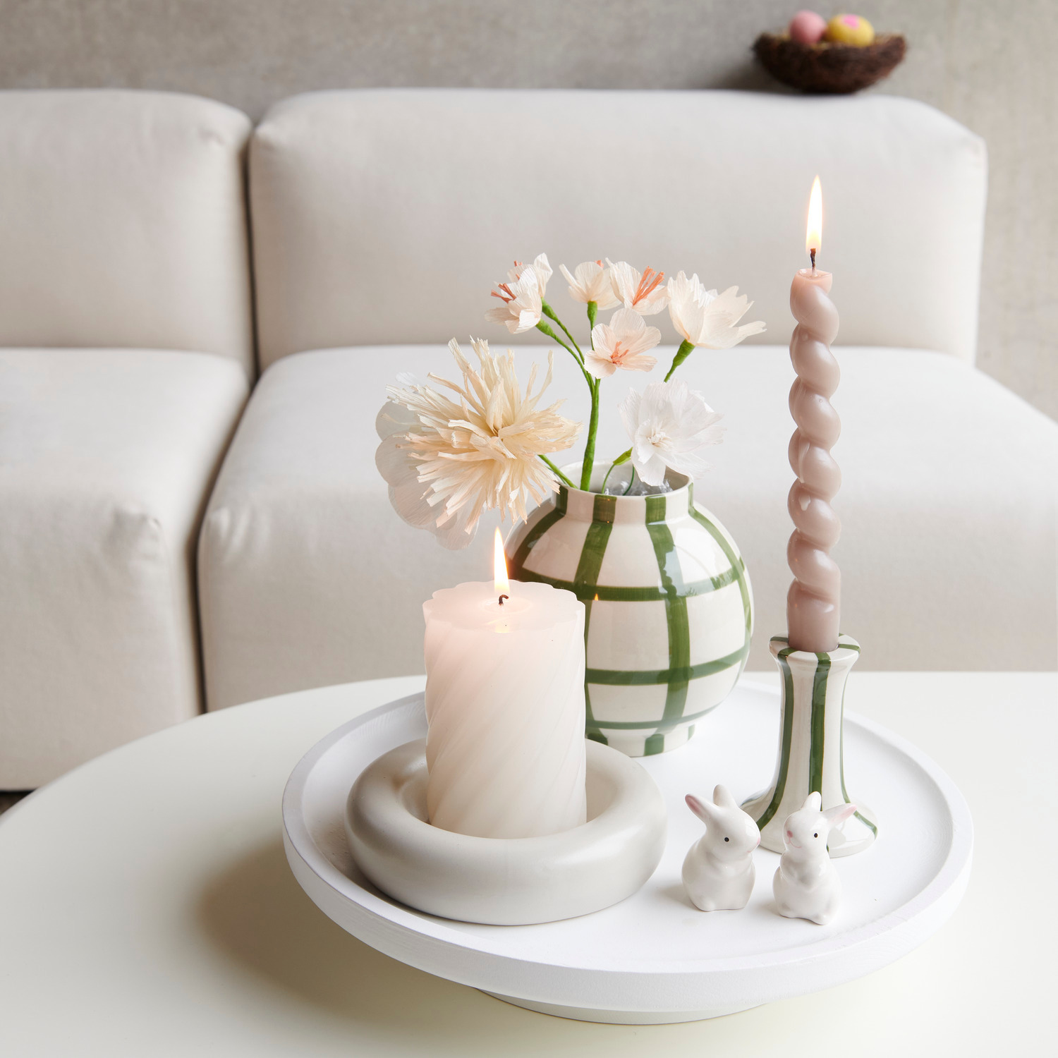 Stumpenkerze Spirale 7x10cm Farbe Eierschale von Rico Design Porzellan Vase, Grün gestreift mit Papierblumen und Spiralkerze auf rundem Holztablett dekoriert.