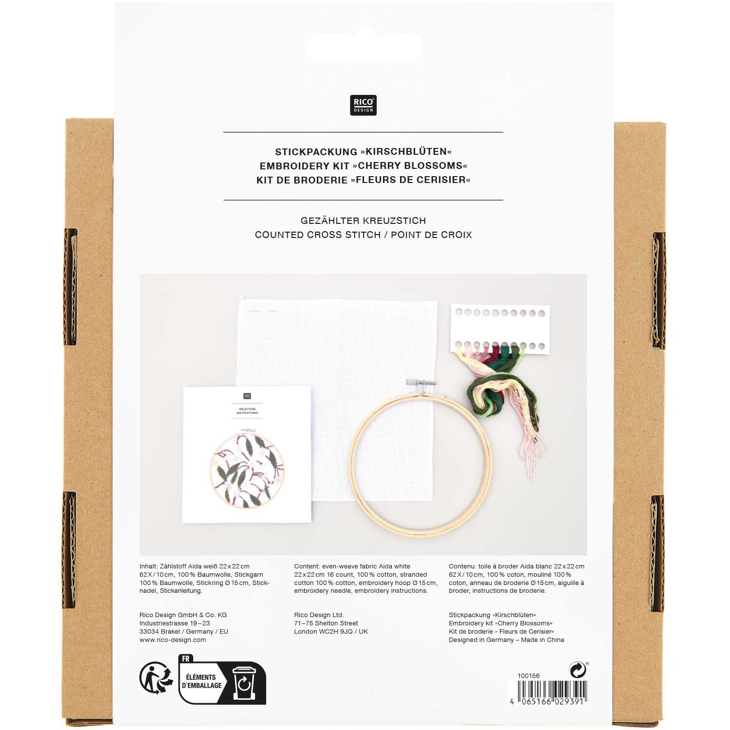 Pack de broderie Image Fleurs de cerisier Ø15cm from Rico Design Stickpackung Bild Kirschblüten Ø15cm von Rico Design, zeigt Stickrahmen, Garn und Anleitung auf weißem Hintergrund.