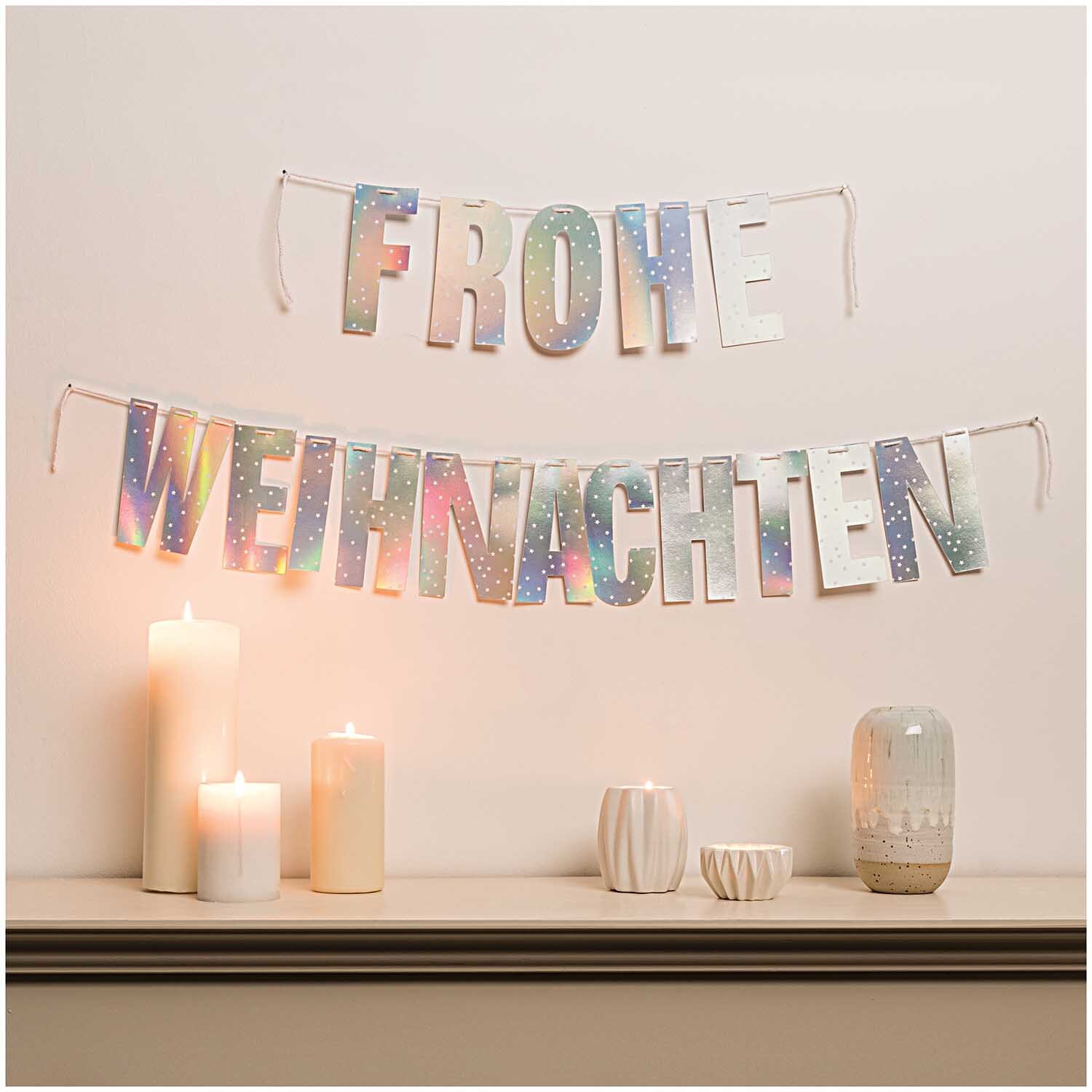 Paper Poetry Girlande Frohe Weihnachten 3m Hot Foil Farbe Silber Irisierend von Rico Design Paper Poetry Girlande Frohe Weihnachten 3m Hot Foil, silber irisierend, dekoriert eine Wand über Kerzen.