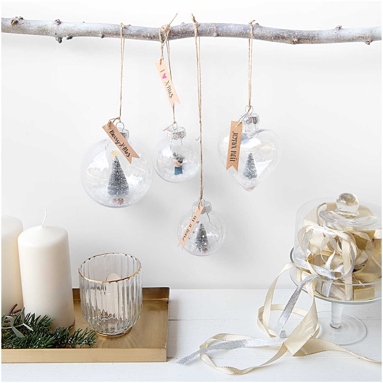 Weihnachtskugel Herz aus Kunststoff 9x10x5,5cm von Rico Design Weihnachtskugel Herz aus Kunststoff von Rico Design, transparent, hängt an einem Ast, umgeben von weiteren Dekorationen.