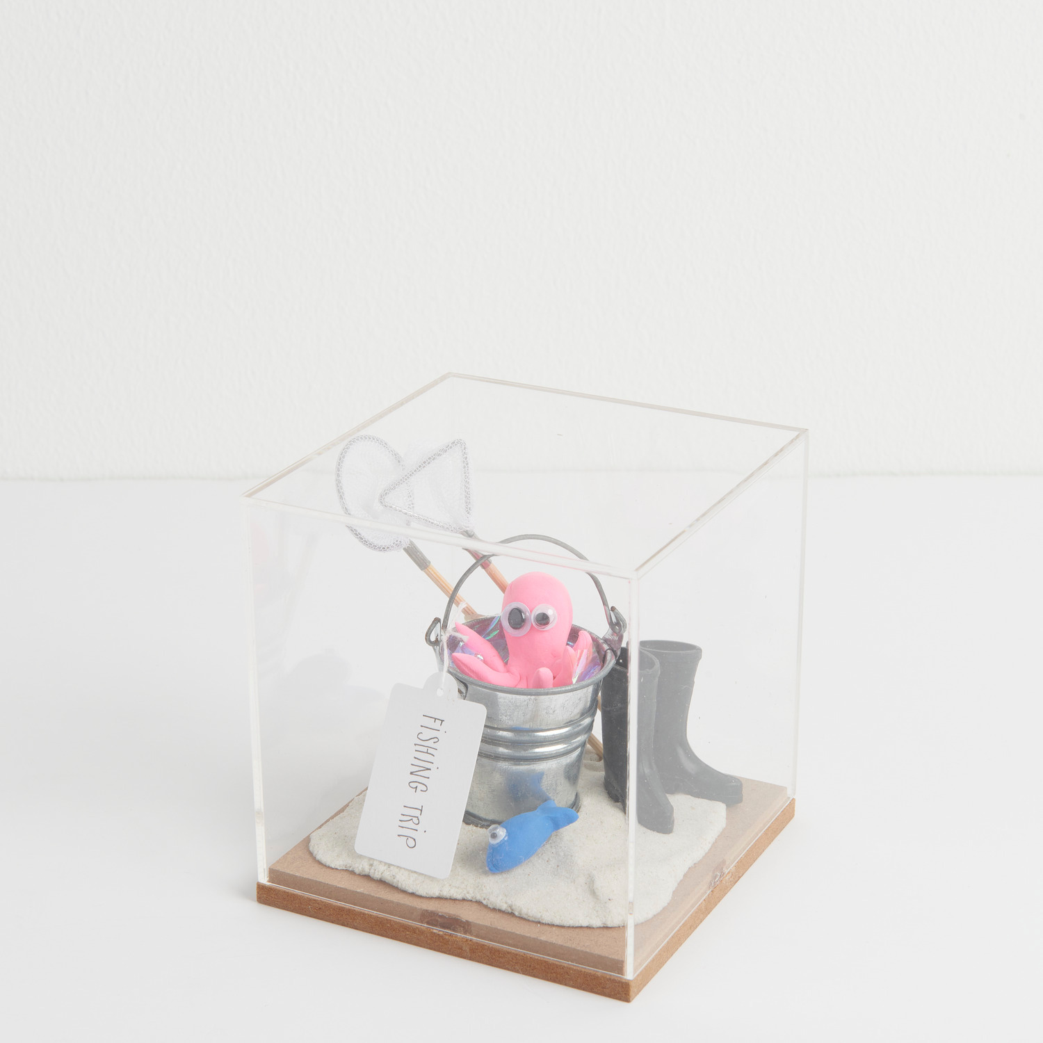 Figurico Dekohaube Würfel Größe 9,5x9,5x10cm von Rico Design Miniatur Fischkescher: Figurico Dekohaube Würfel mit rosa Oktopus, Eimer und Stiefel auf Sand.