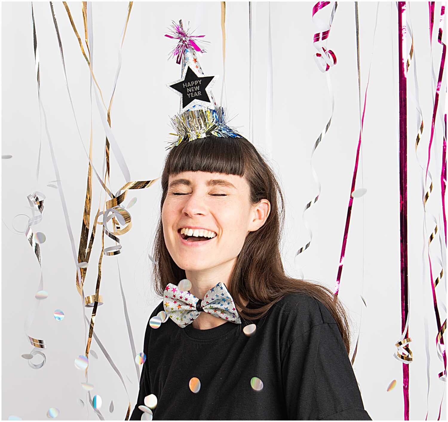 Haarreif und Fliege Happy New Year Sterne bunt 2-teilig von Rico Design Haarreif und Fliege Happy New Year Sterne bunt, getragen von einer lachenden Person, umgeben von bunten Luftschlangen.