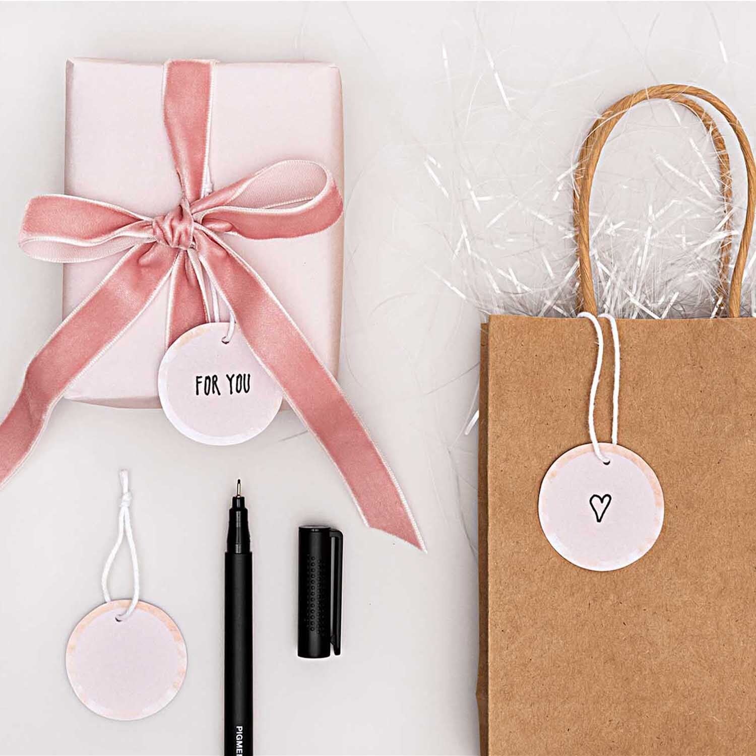 Paper Poetry Papieranhänger Kreise 4cm 24 Stück Farbe Puder von Rico Design Paper Poetry Papieranhänger Kreise 4cm 24 Stück in Puder, dekoriert mit Geschenk und Tüte. Ideal für kreative Verpackungen.