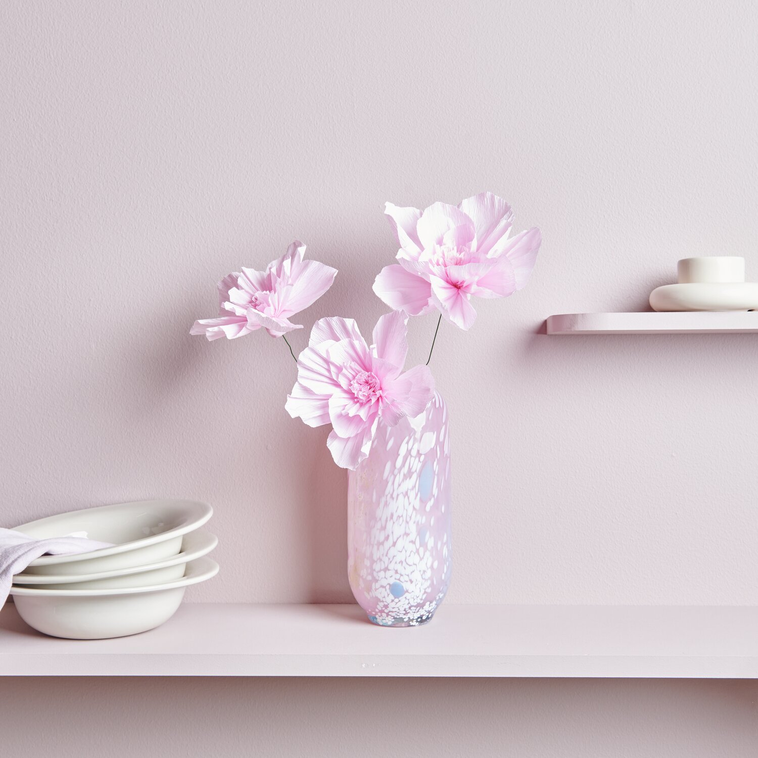 Krepppapier Blüten 3 Stück Farbe Rosa von Rico Design Krepppapier Blüten in zartem Rosa von Rico Design, arrangiert in einer eleganten Vase auf einem Regal.