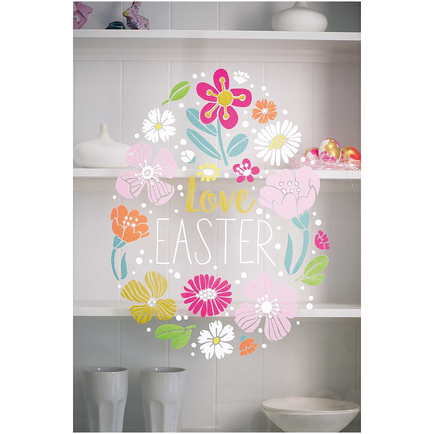 Vorlagenmappe Ostern Fenster- und Glasmalerei mit Kreidestiften von Rico Design Vorlagenmappe Ostern Fenster- und Glasmalerei zeigt bunte Blumen und den Schriftzug "Love Easter" auf einem Regal.