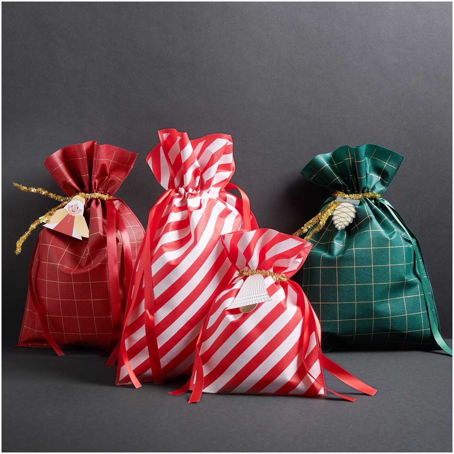 Paper Poetry Geschenktasche rot-weiß 20x30cm von Rico Design, umgeben von weiteren dekorativen Geschenktaschen in verschiedenen Mustern und Farben.