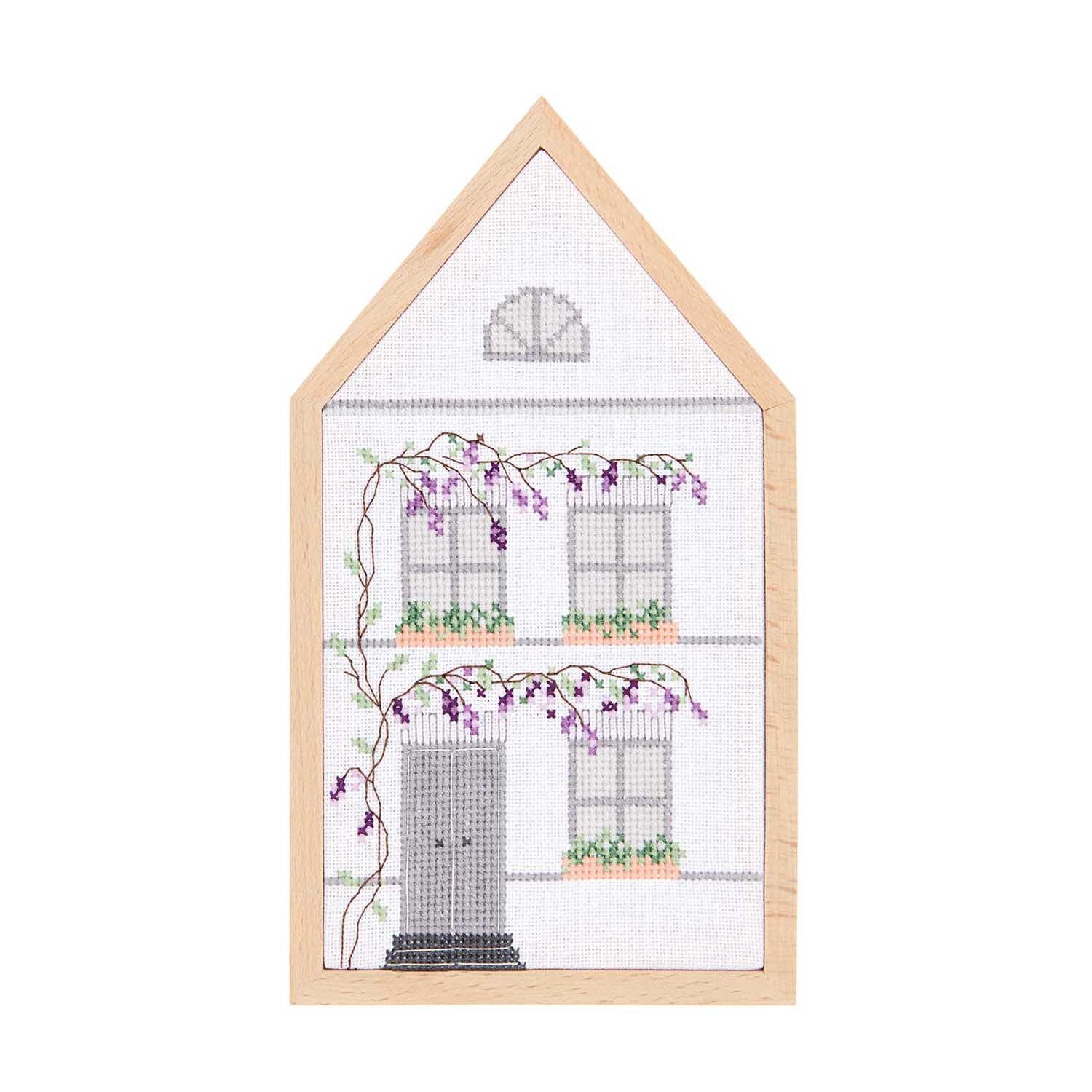 Stickpackung Sommerhaus mittel zeigt ein gesticktes Haus mit Blumenranken, 12x22,5cm, von Rico Design.
