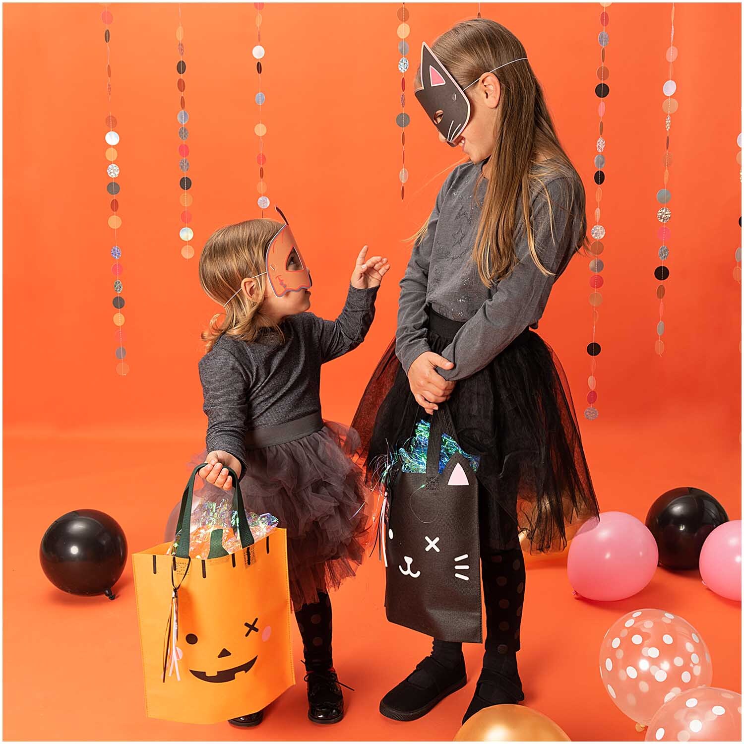 Paper Poetry Geschenktüte Kürbis 28x30cm von Rico Design Paper Poetry Geschenktüte Kürbis 28x30cm: Zwei Kinder in Halloween-Kostümen mit Geschenktüten vor orangefarbenem Hintergrund.