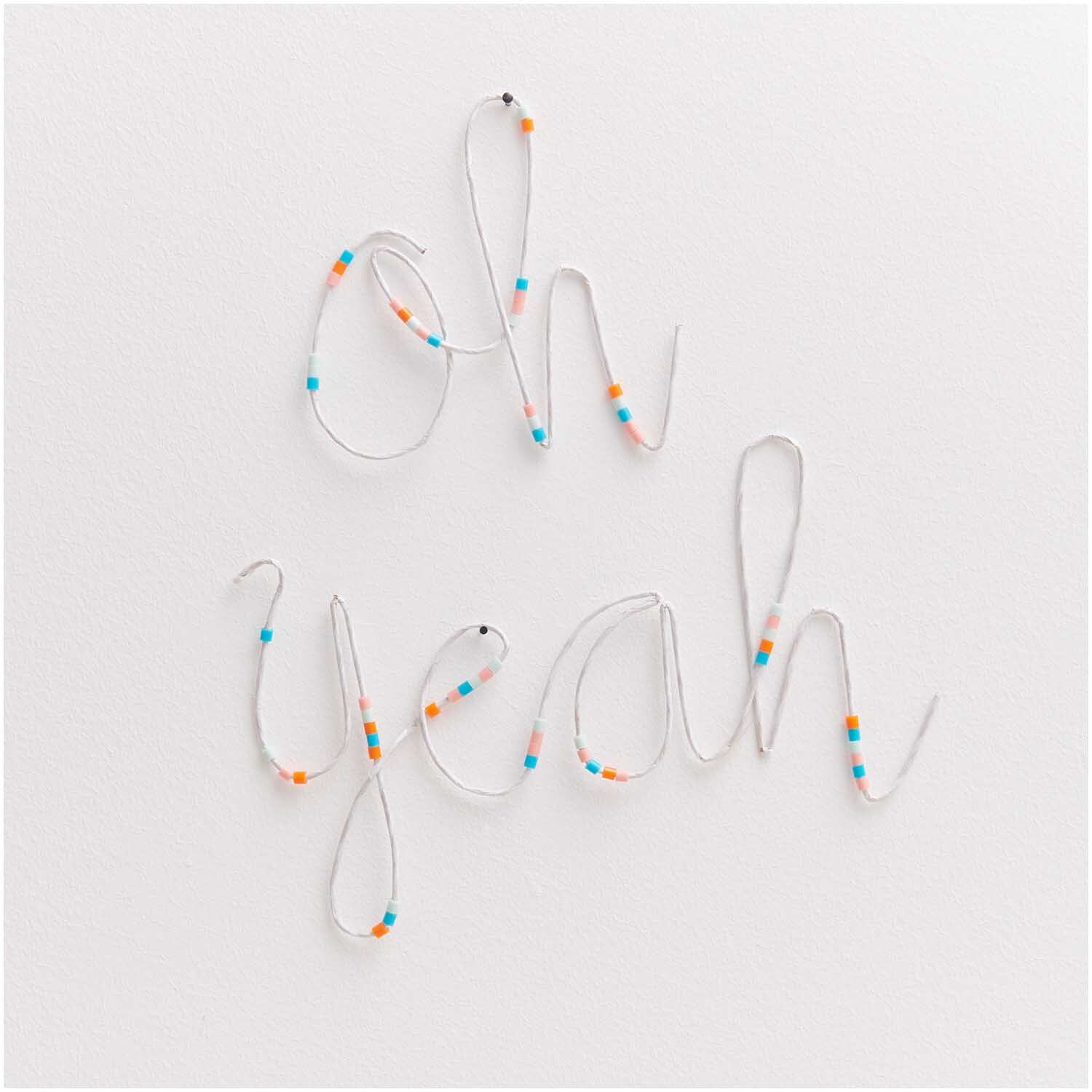 Papierdraht 1,8mm 1m 10 Stück Farbe Weiß von Rico Design Papierdraht 1,8mm 1m 10 Stück formt die Worte "oh yeah" mit bunten Perlen auf weißem Hintergrund.