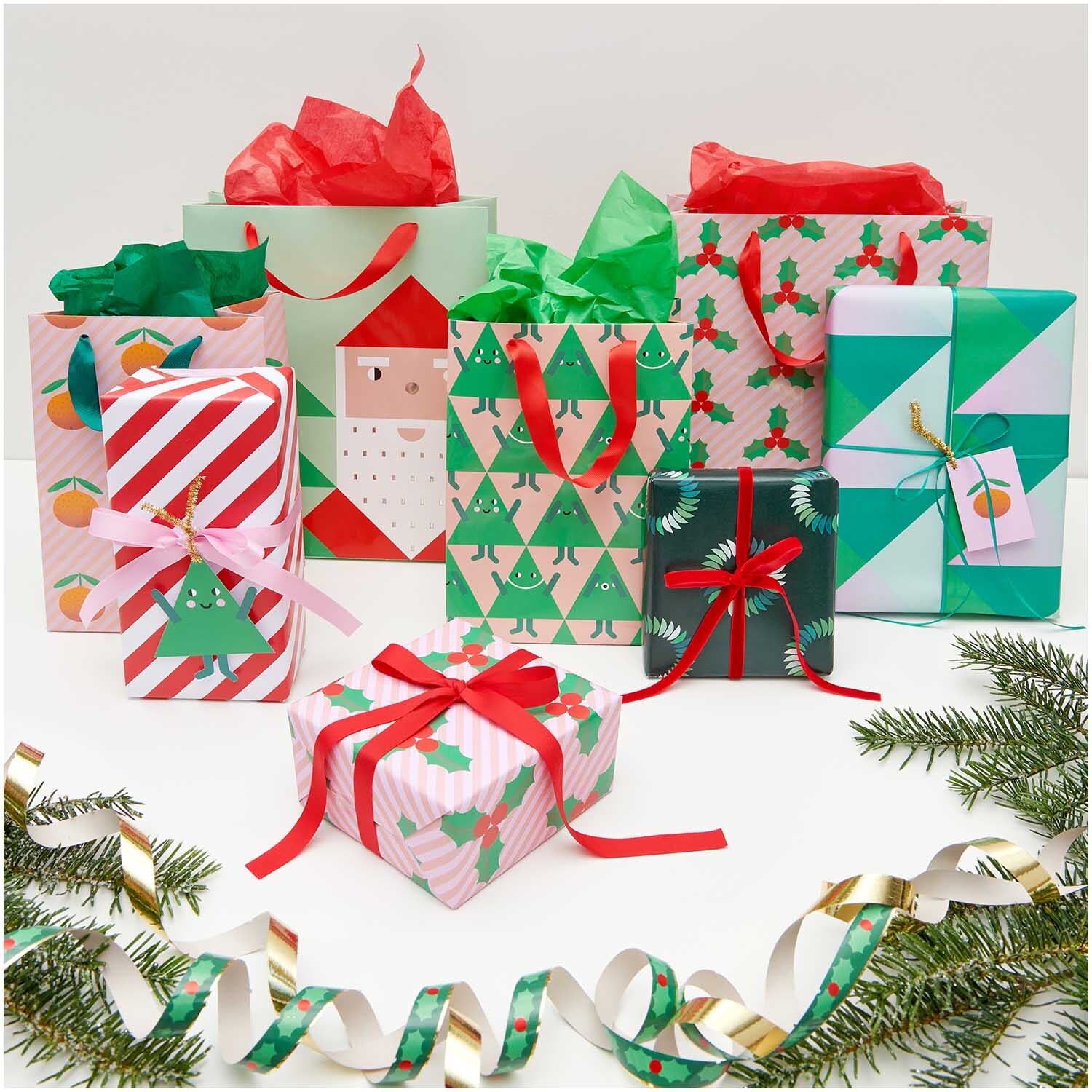 Paper Poetry Geschenktüte Ilex 26x32x12cm von Rico Design Paper Poetry Geschenktüte Ilex 26x32x12cm mit festlichen Motiven, umgeben von bunt verpackten Geschenken und Tannenzweigen.
