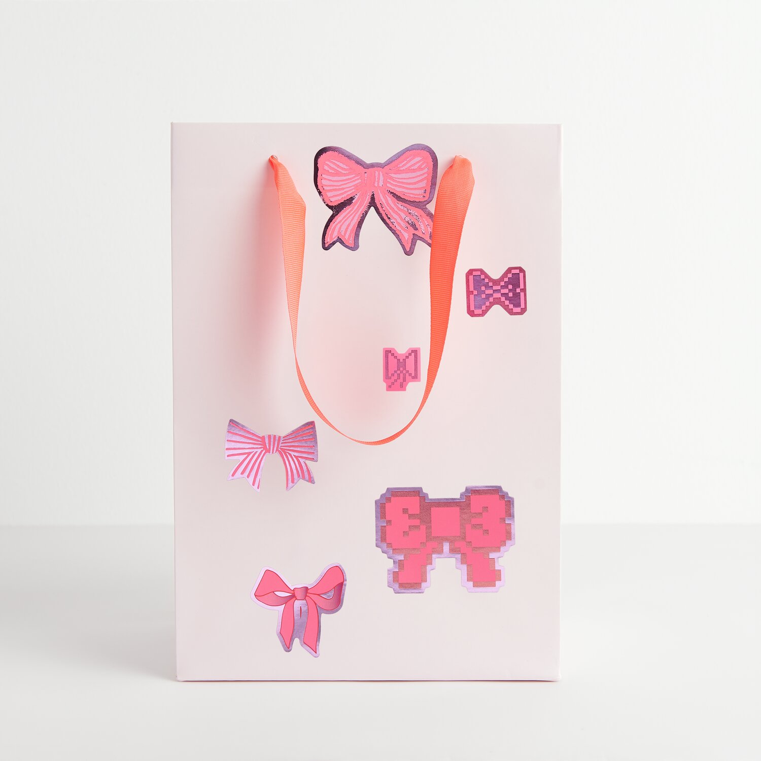 Paper Poetry Sticker Schleifen 100 Stück von Rico Design Paper Poetry Sticker Schleifen auf weißer Geschenktüte mit rosa Schleifenmotiven und Griffen.