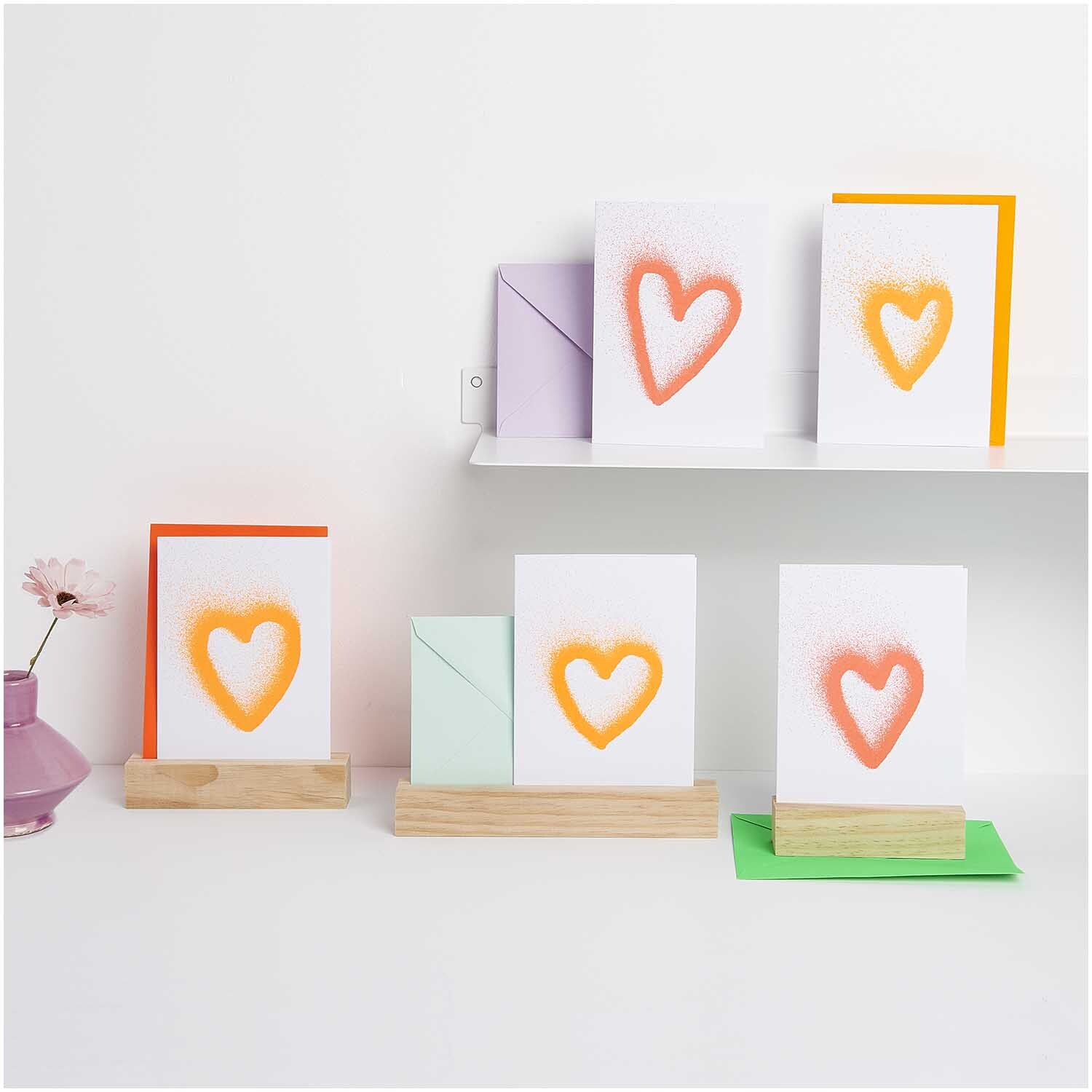 Paper Poetry Kartenset Airbrush Herzen B6 20-teilig von Rico Design Paper Poetry Kartenset Airbrush Herzen B6 zeigt Karten mit orangefarbenen Herzen auf Holzständern.