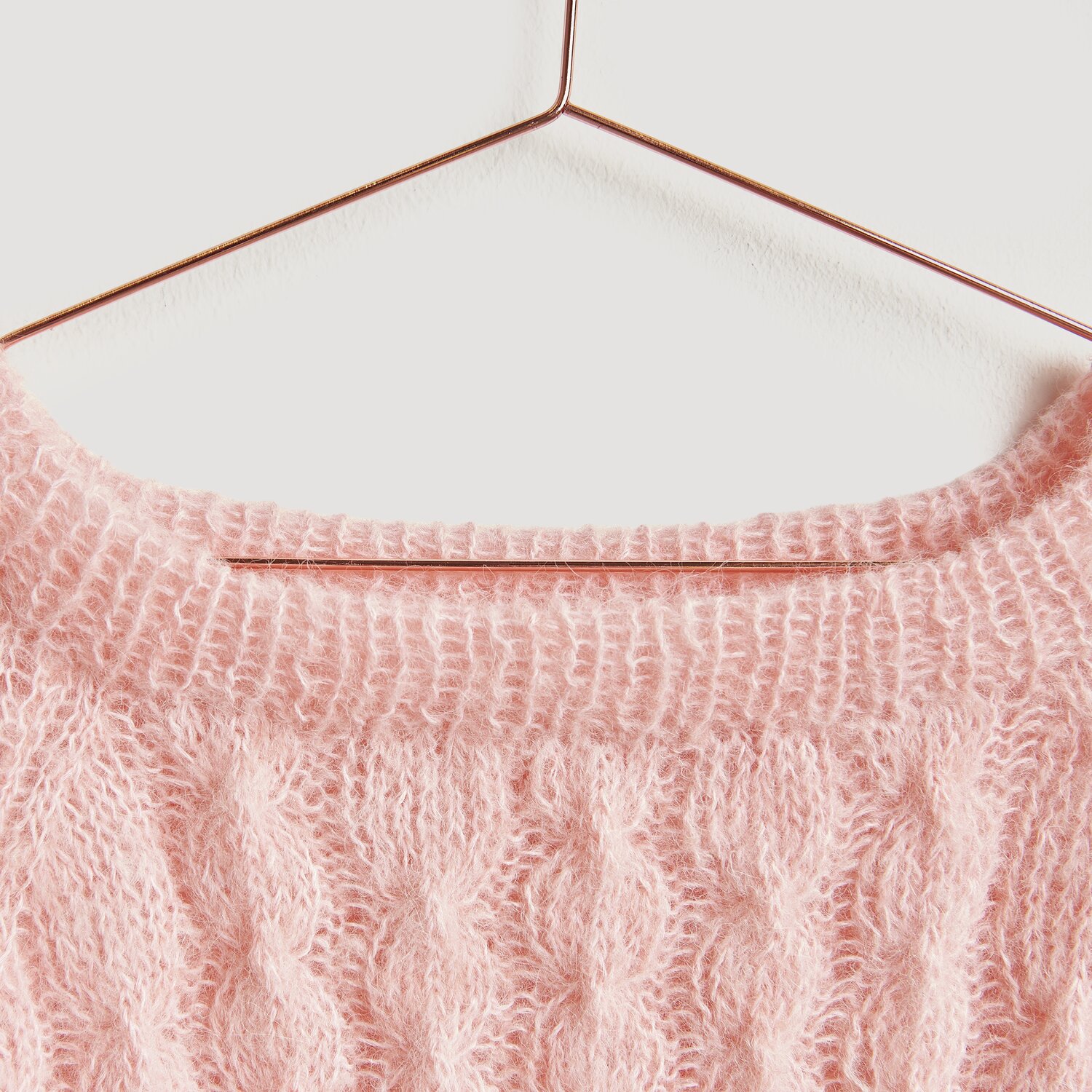 Luxury Alpaca Cotton Fusion Pullover in Apricot auf einem Kupferbügel, gestrickt mit Zopfmuster.