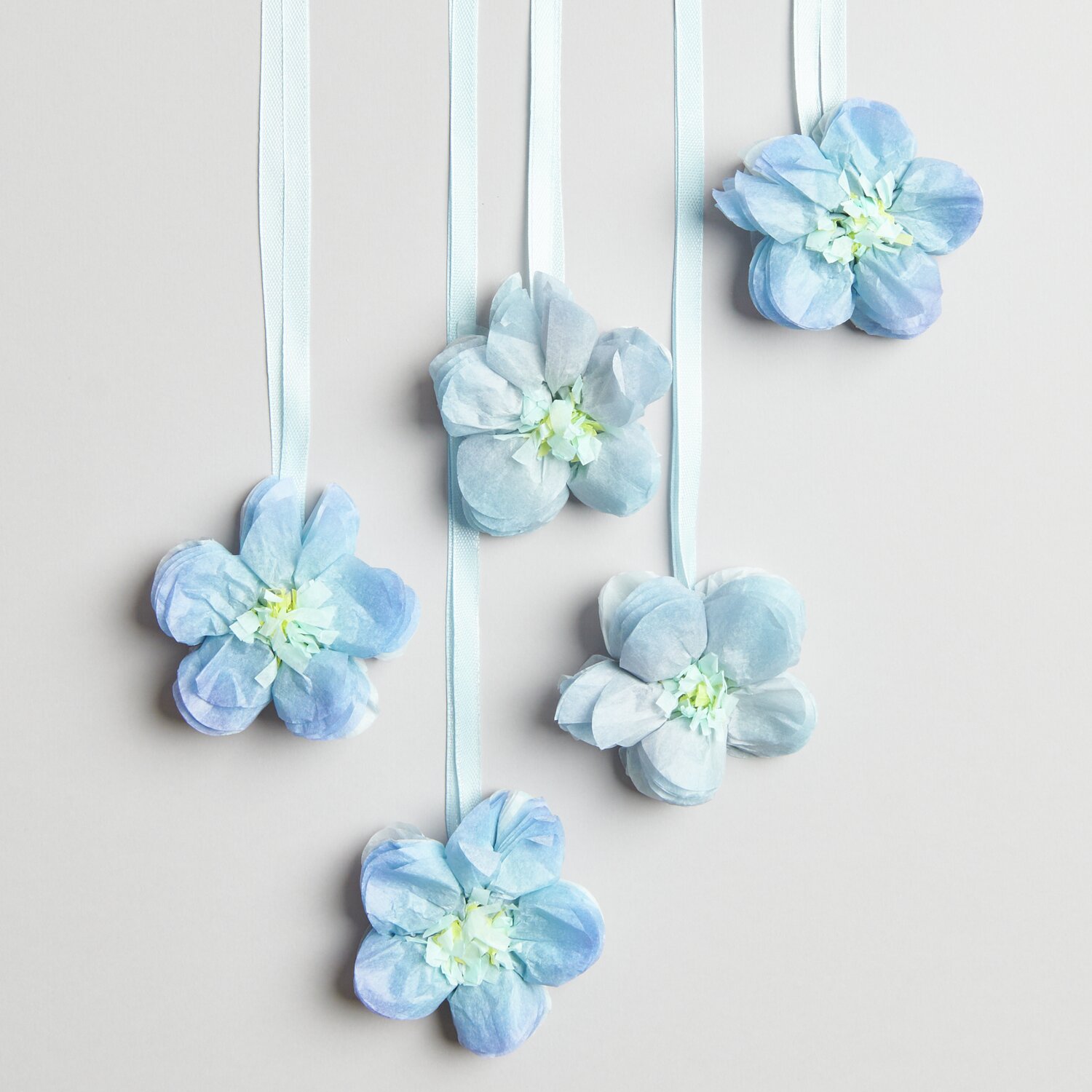 Seidenpapierblumen Vergissmeinnicht 7cm von Rico Design, fünf blaue Blumen an Bändern hängend.