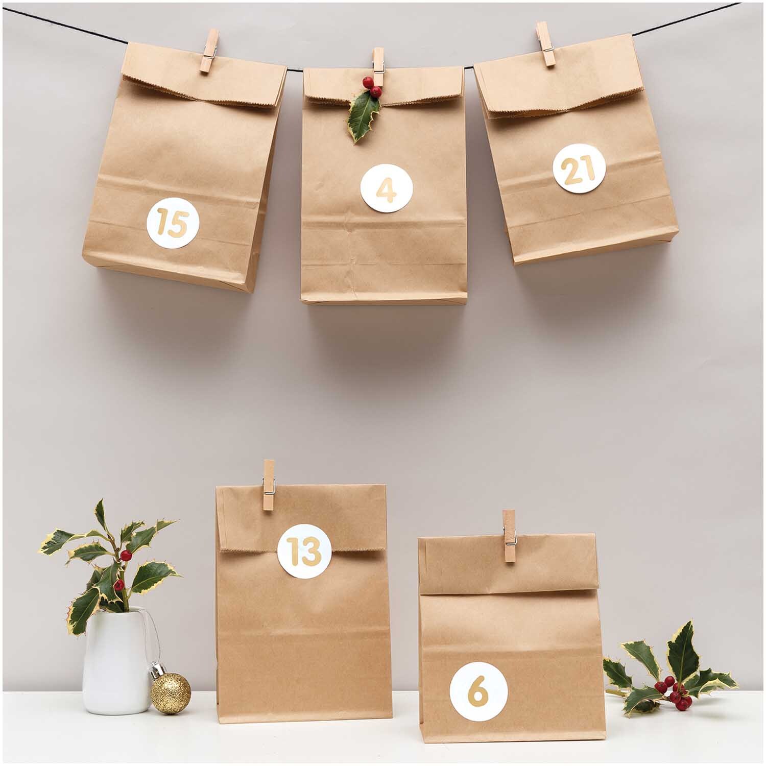 Paper Poetry Adventskalenderset Kraftpapier mit 24 braunen Tüten, dekoriert mit Zahlen.