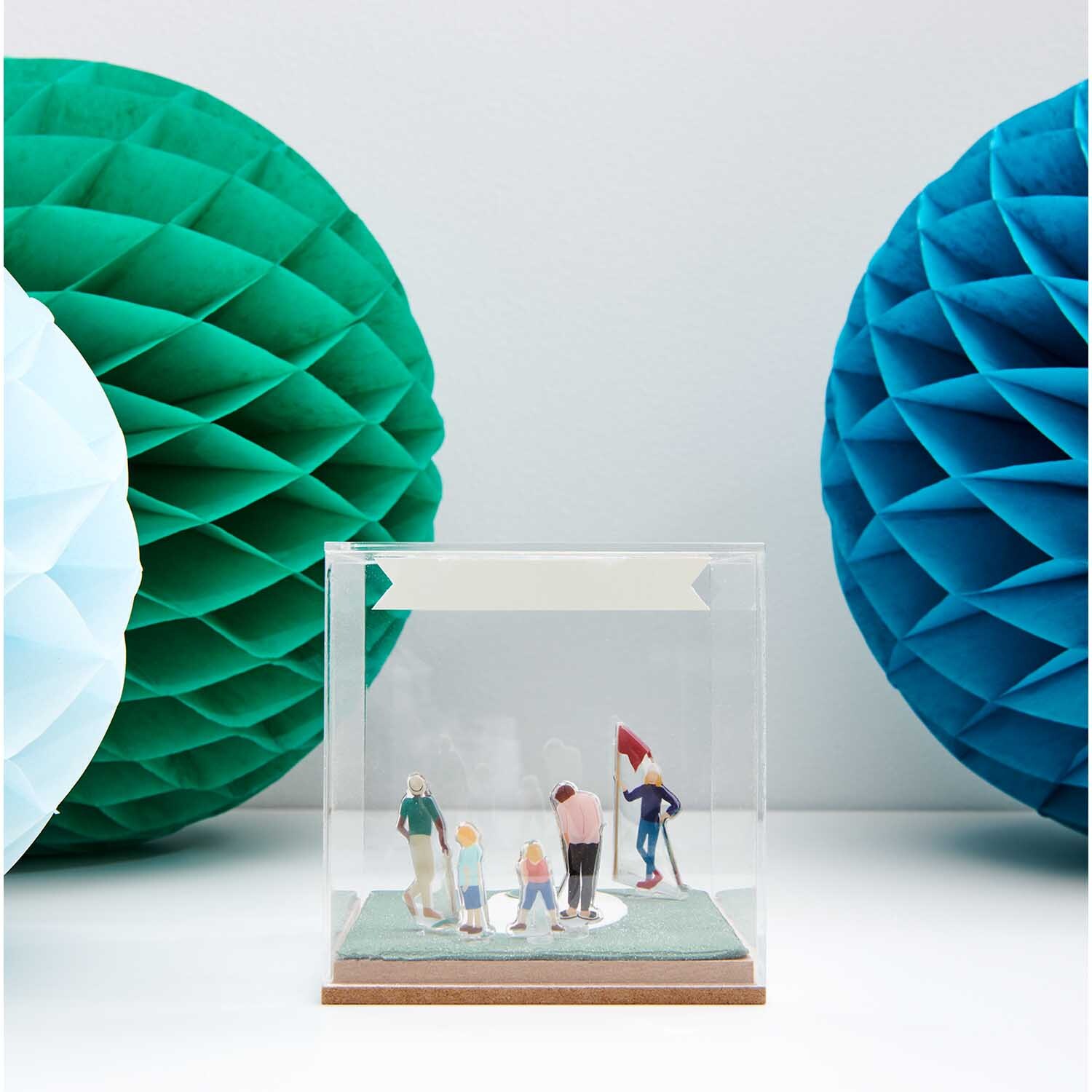 Figurico Gelsticker Golfspieler: Miniatur-Golfspieler in Acrylbox, umgeben von grünen und blauen Wabenbällen.
