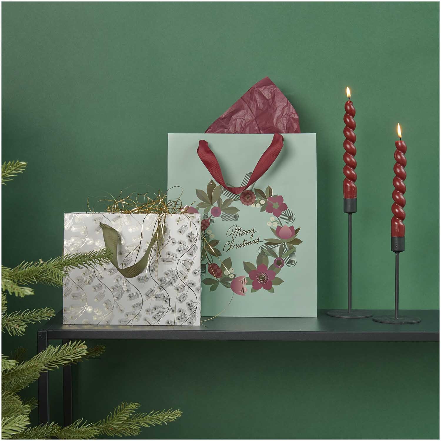 Paper Poetry Geschenktüte Kranz türkis-bordeaux-grün 26x32x12cm von Rico Design Paper Poetry Geschenktüte mit Kranzmotiv, dekoriert mit roten Kerzen und Tannenzweigen auf grünem Hintergrund.