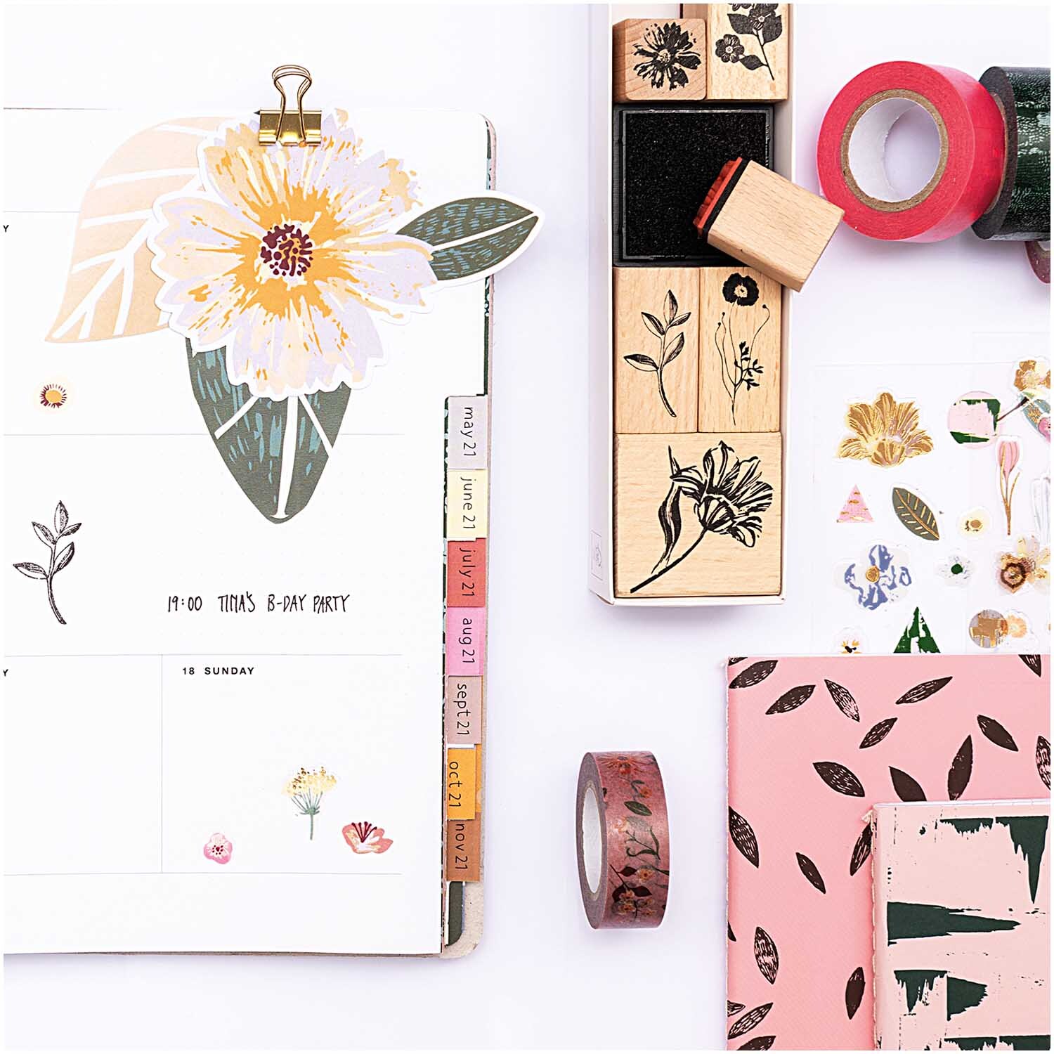 Paper Poetry Stempelset Blumen, 7-teilig, zeigt florale Stempel und Washi-Tapes auf einem Schreibtisch. Ideal für kreative Projekte.