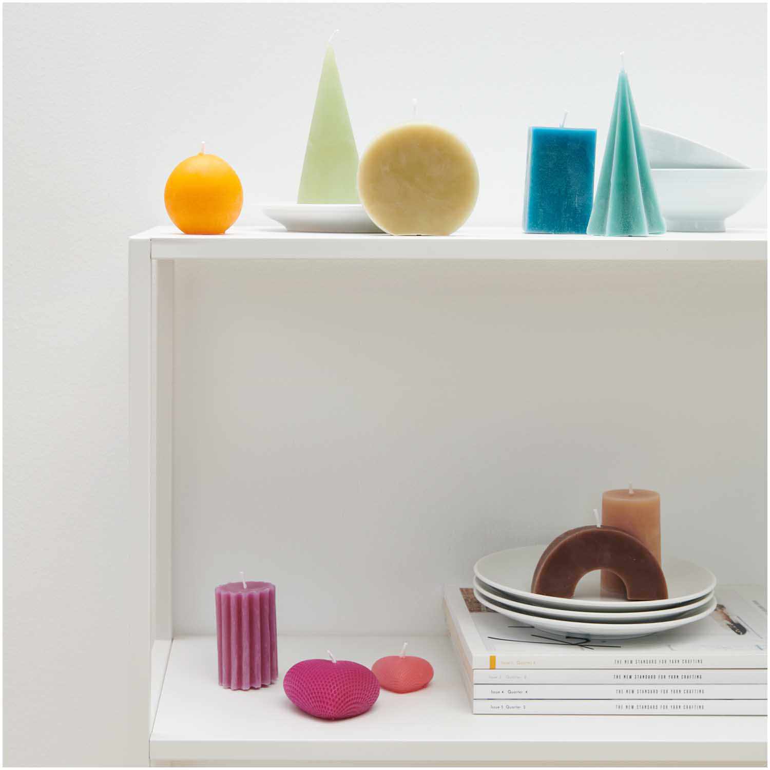 Kerzengießform Sternenkegel 70x70x135mm von Rico Design Kerzengießform Sternenkegel von Rico Design auf einem Regal mit bunten Kerzen und Tellern.