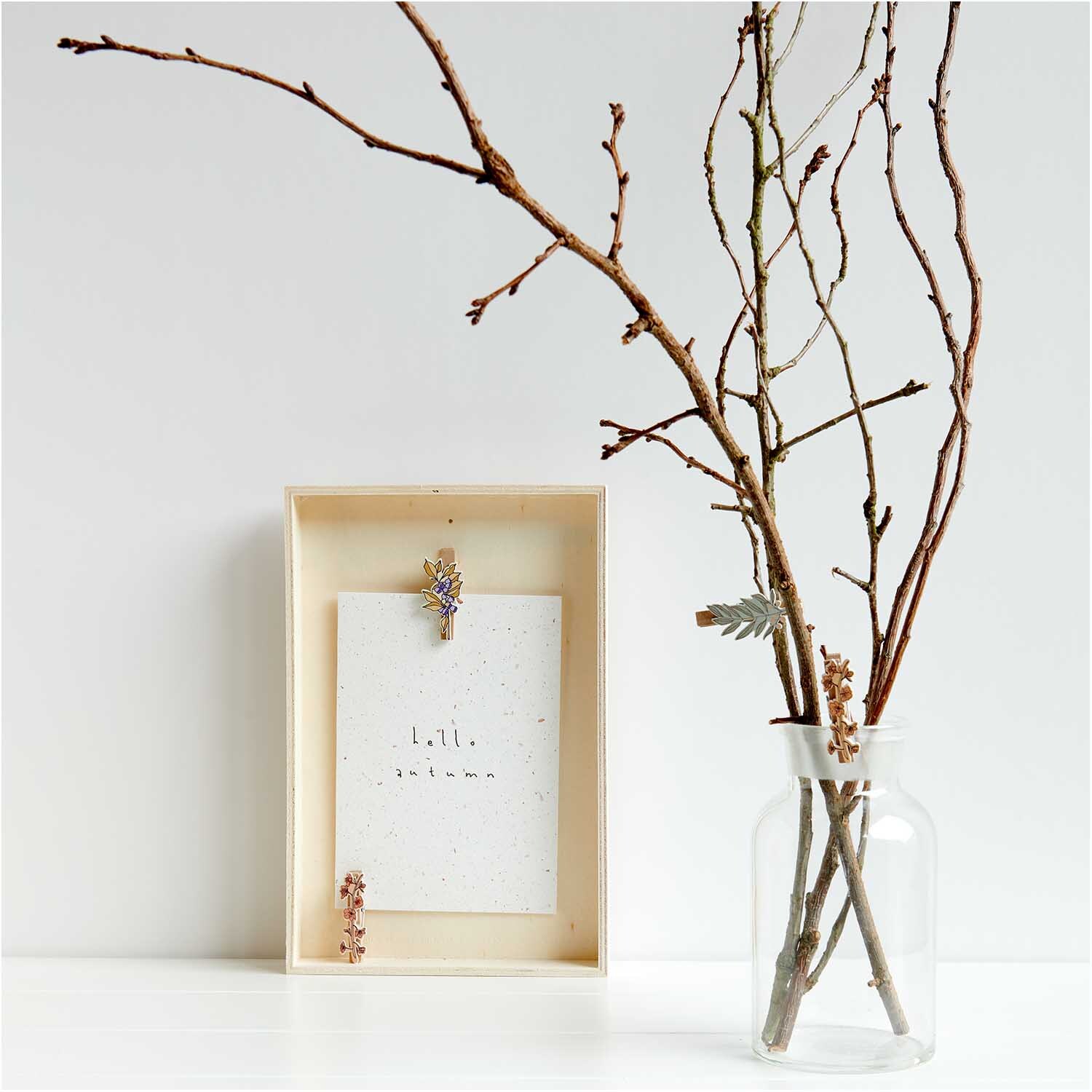 Holzclips Blumen Mix bunt 4,8cm 4 Stück von Rico Design Holzclips Blumen Mix bunt 4,8cm 4 Stück: Mehrfarbige Clips von Rico Design an einem Holzrahmen, daneben ein Glas mit Zweigen.