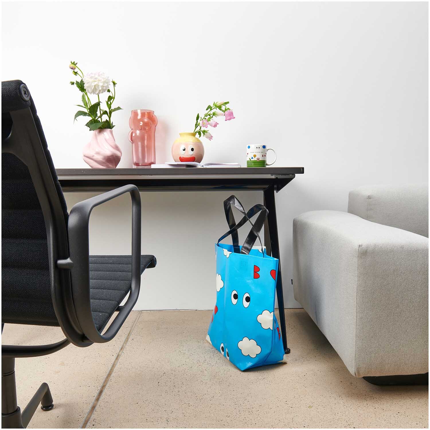 Rico Design x Redfries Shopper Wolken blau 54x43x20cm von Rico Design Rico Design x Redfries Shopper Wolken blau steht neben einem modernen Schreibtisch mit Blumen.