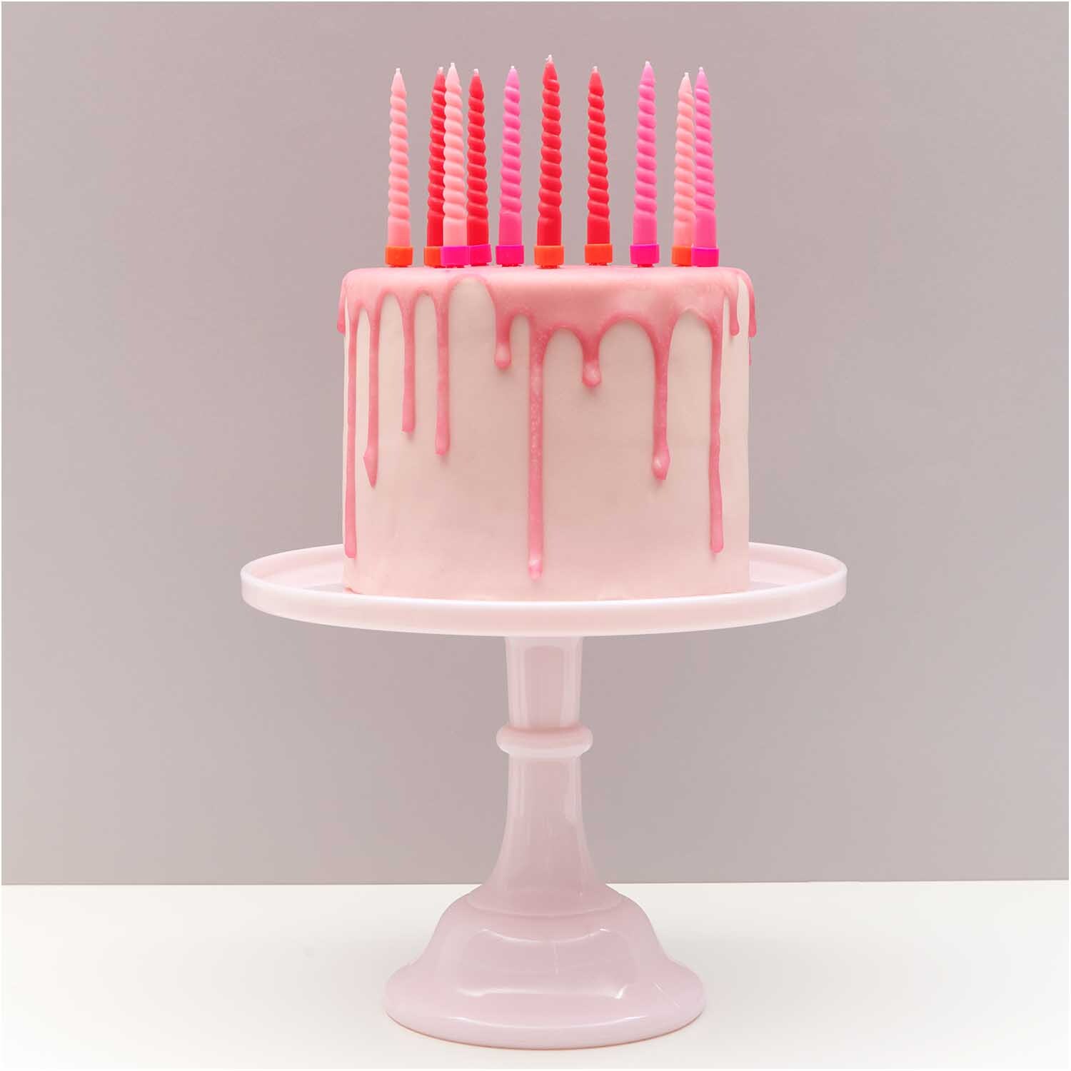 Spiral Kerzenhalter neon 1,2cm 10 Stück: Rosa Torte mit neonfarbenen Kerzen auf weißem Ständer.