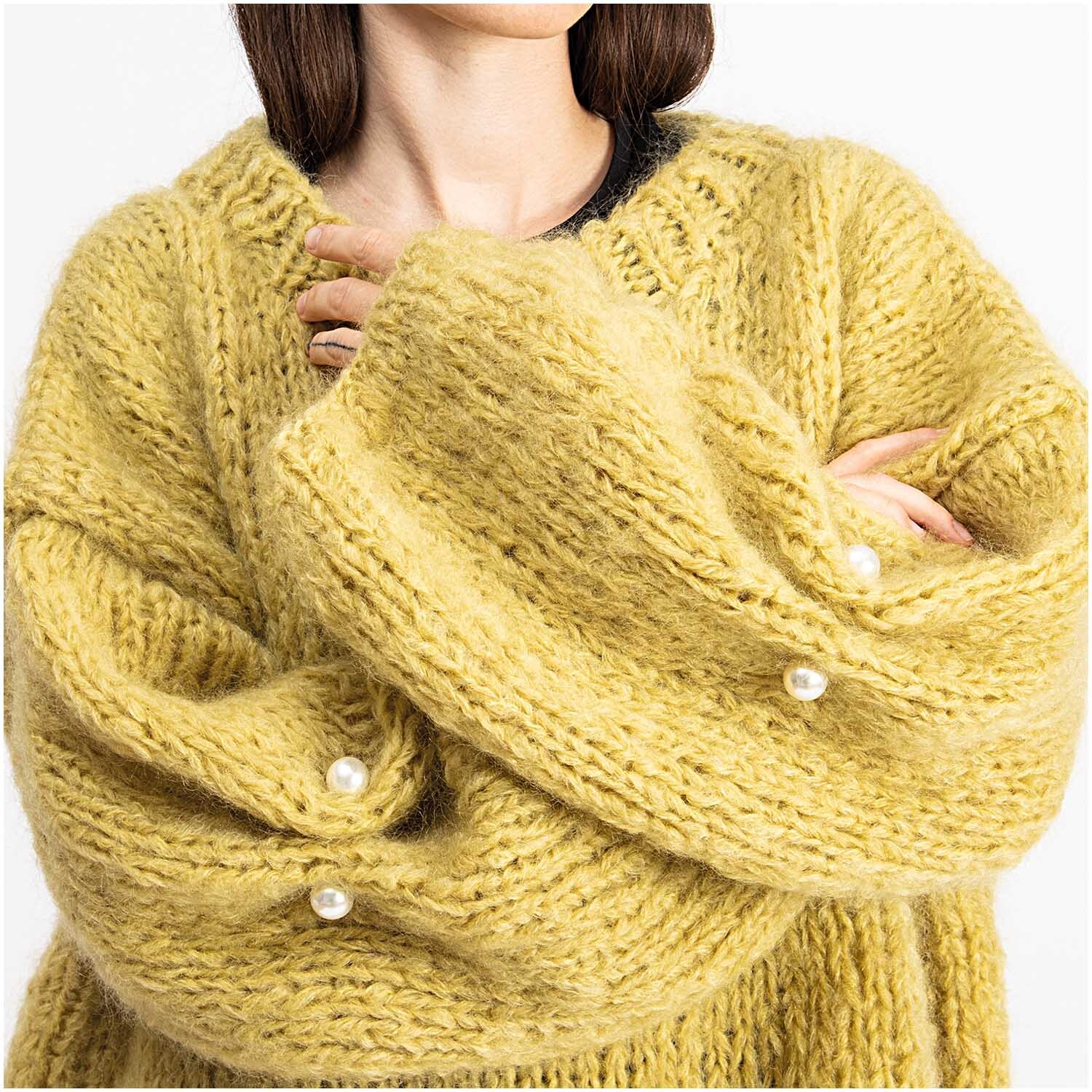 Zwei-Perlen-Pin 65mm 1 Stück Farbe Perlweiß von Rico Design Zwei-Perlen-Pin 65mm 1 Stück: Frau in gelbem Strickpullover mit Perlweiß-Pins von Rico Design an den Ärmeln.