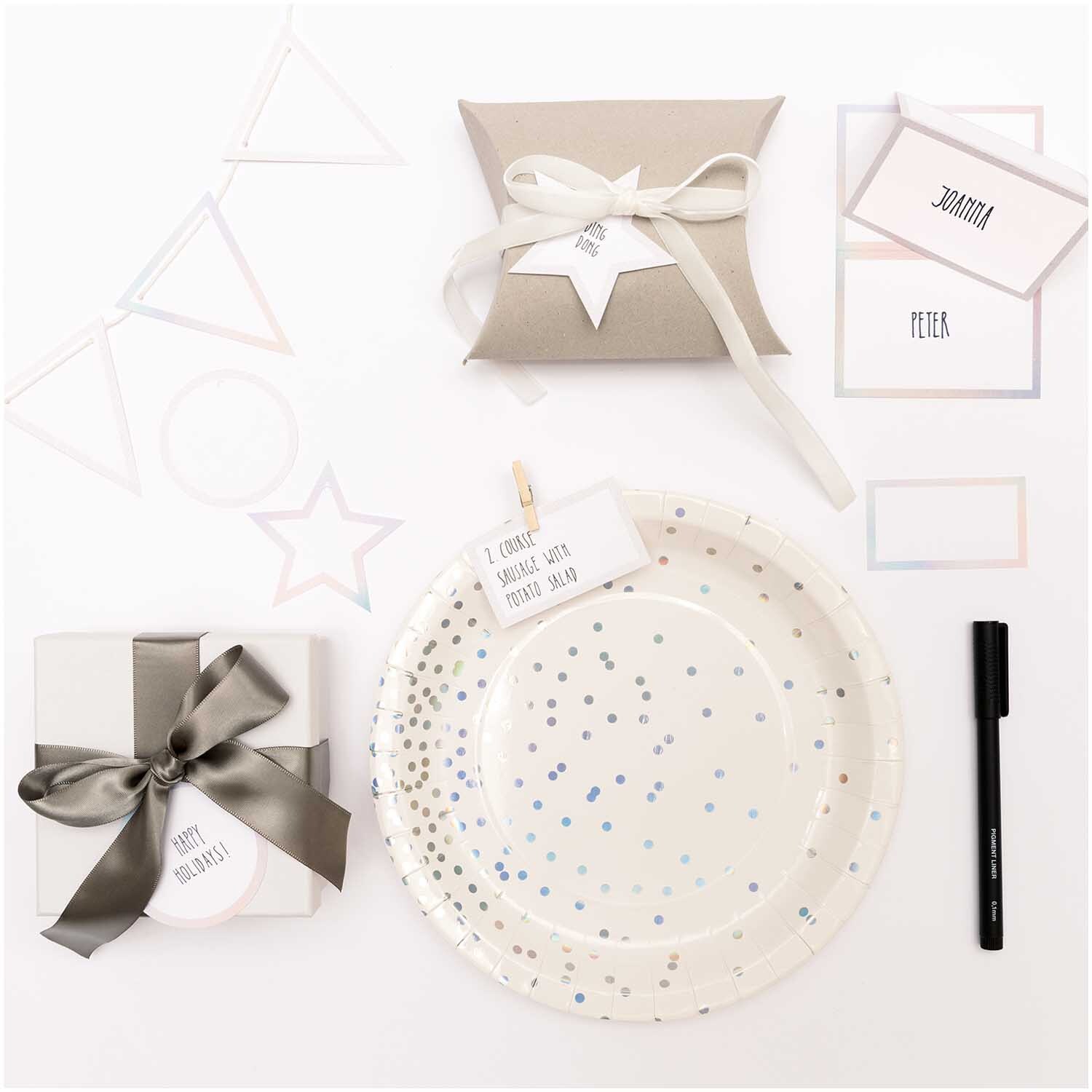 Paper Poetry Papierkärtchen mit Hot Foil, umgeben von dekorativen Geschenken und irisierenden Akzenten.