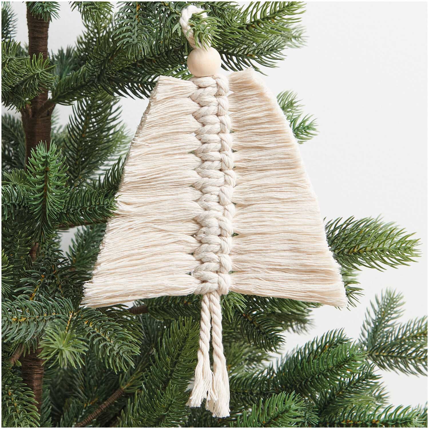 Set macramé sapins 20x12cm 2 pièces from Rico Design Makramee Set Tannenbäume von Rico Design, beige, hängt dekorativ an einem grünen Tannenzweig.