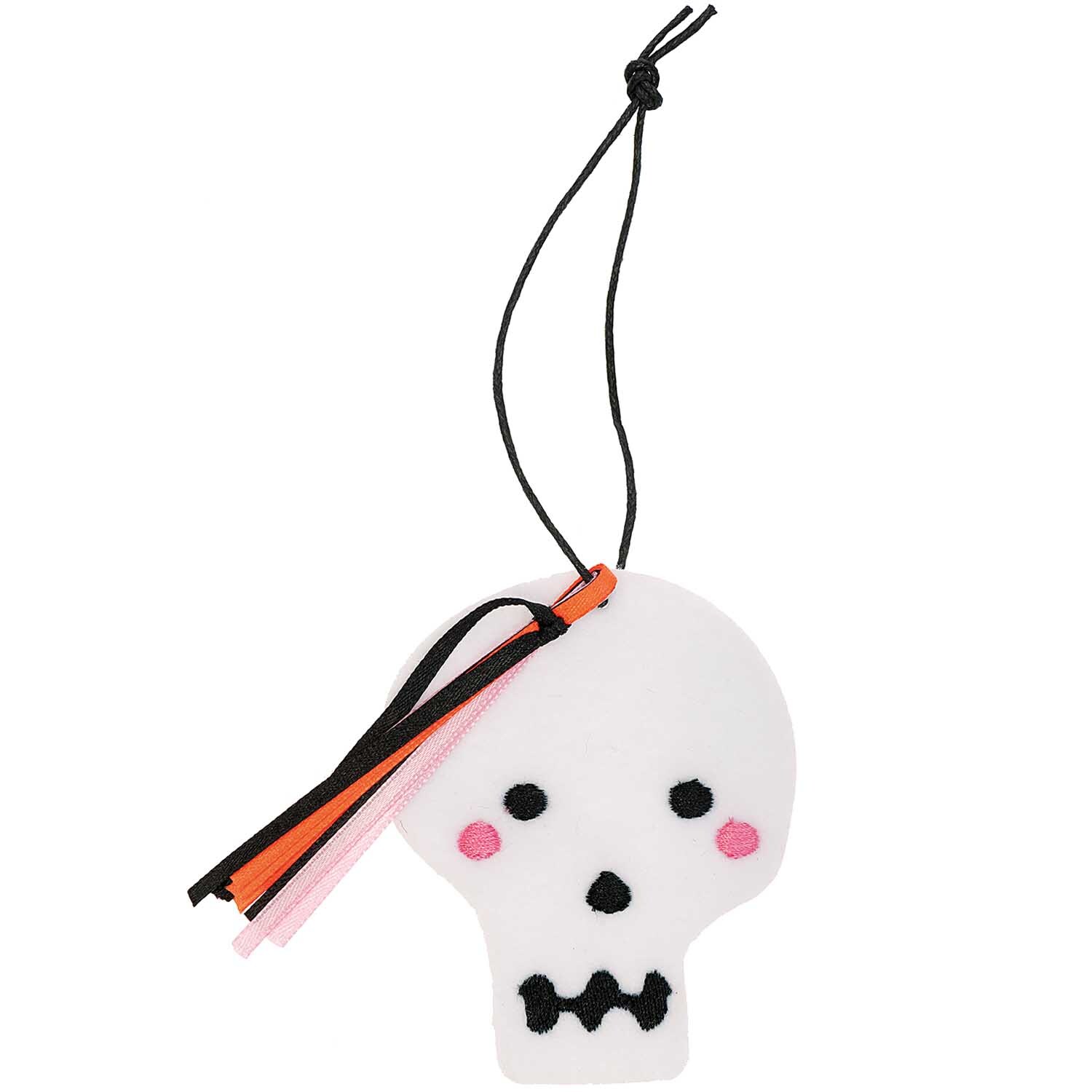 Filzhänger Totenkopf aus weißem Filz mit schwarzen und rosa Details, verziert mit bunten Bändern. Ideal für Halloween-Dekorationen.