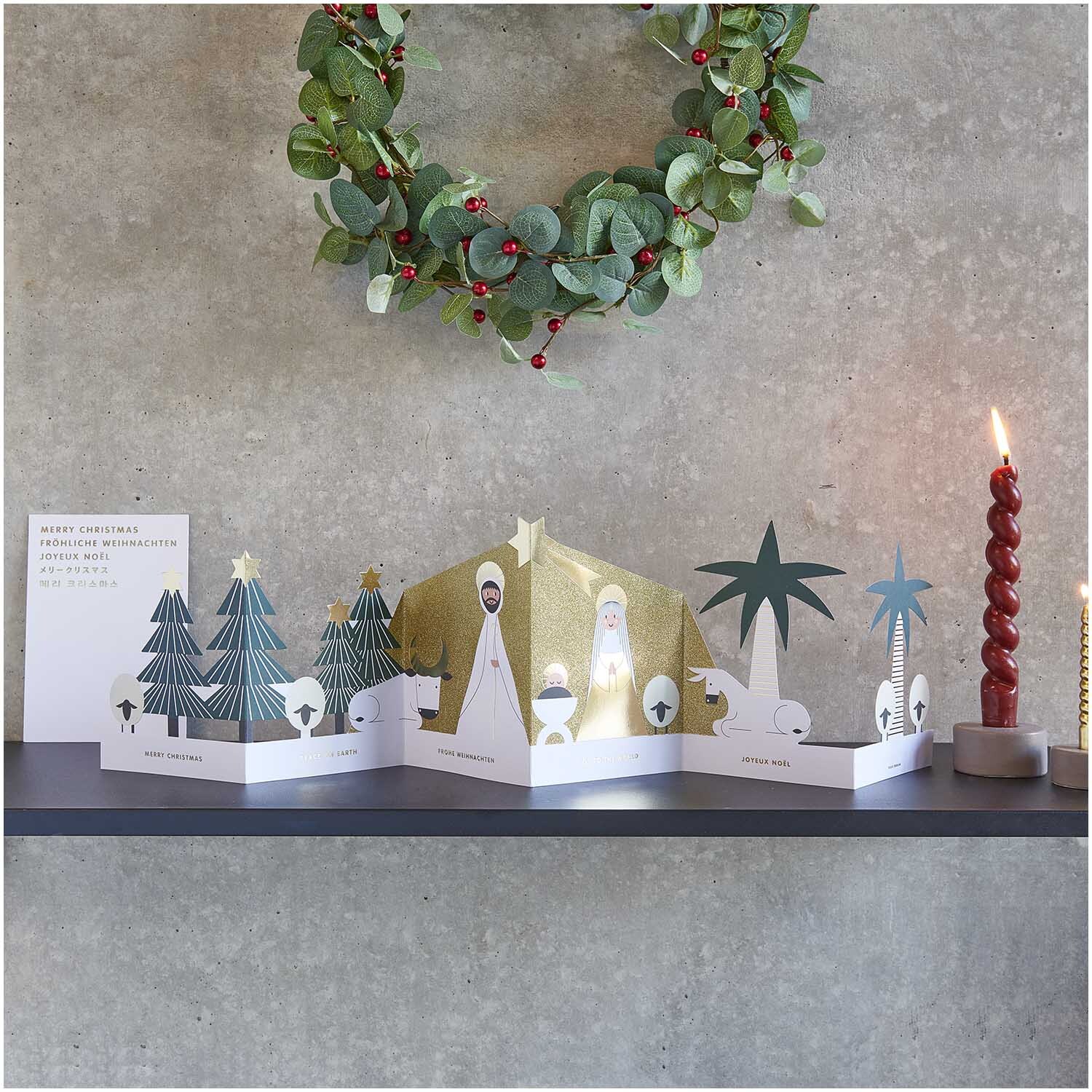 Paper Poetry Zickzack-Karte Holy Family 73x17cm von Rico Design Paper Poetry Zickzack-Karte Holy Family zeigt eine weihnachtliche Szene mit Bäumen und Kerzen.