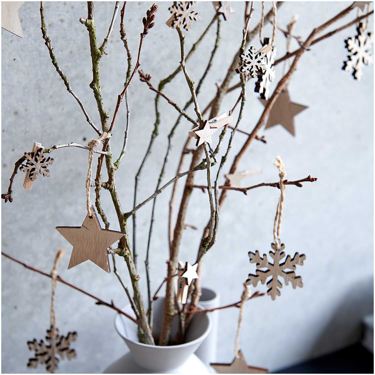 Dekoklammern Schneeflocke natur 3cm 8 Stück von Rico Design Dekoklammern Schneeflocke natur 3cm 8 Stück an Zweigen in einer Vase, ideal für winterliche Dekorationen.