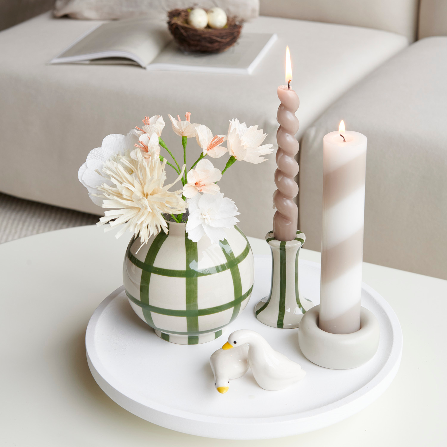 Holztablett rund mit Porzellan Vase grün gestreift, Kerzenhaltern und Keramik Gans in Weiß.