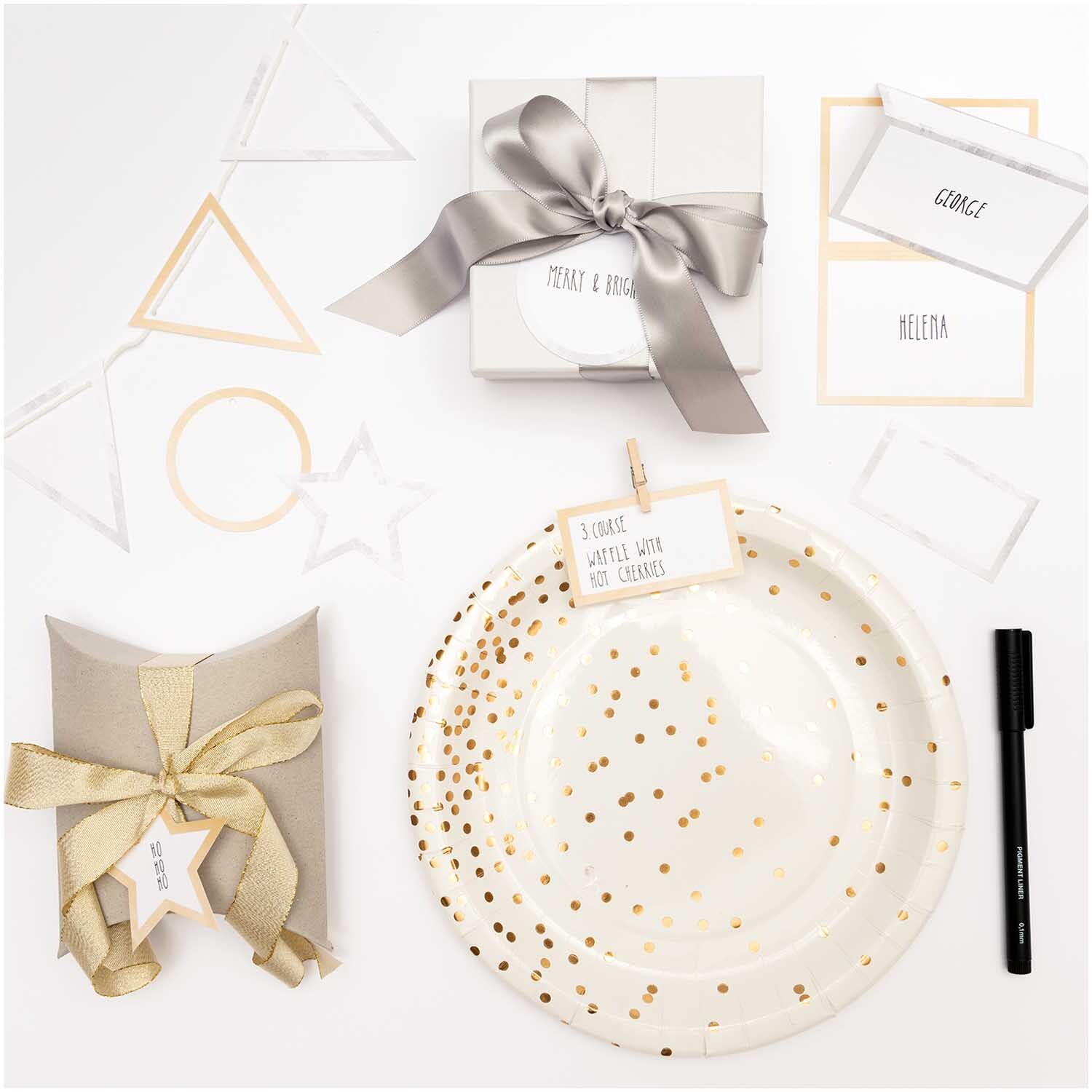 Paper Poetry Papieranhänger Stern mit Hot Foil 6,5x6,5cm 24 Stück Farbe Gold von Rico Design Paper Poetry Papieranhänger Stern mit Hot Foil, dekoriert auf einem Tisch mit goldenen Akzenten und Geschenkverpackungen. Ideal für festliche Anlässe.
