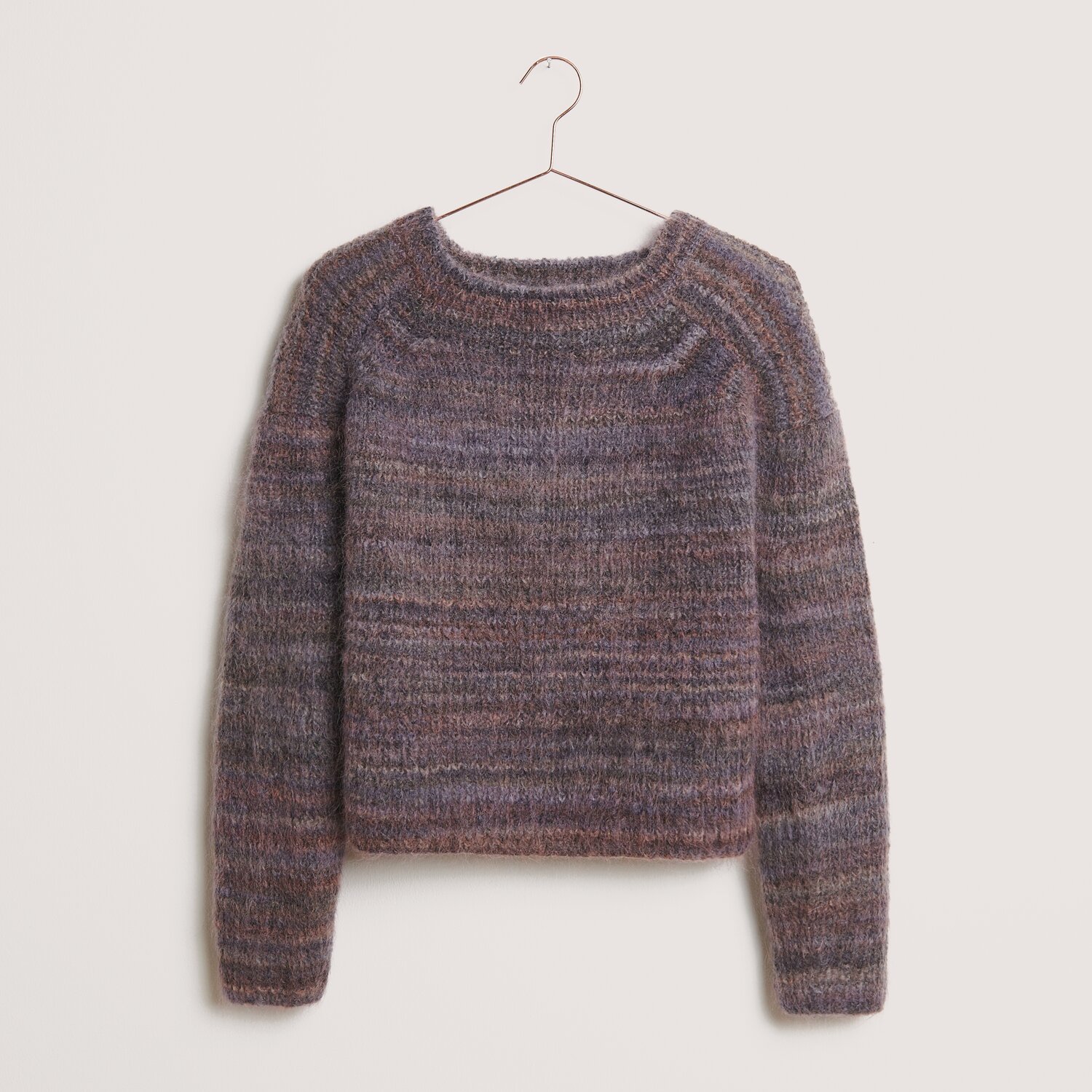 Fashion Meri Mohair Print 50g 275m Couleur Smokey Purple from Rico Design Fashion Meri Mohair Print Pullover in Smokey Purple von Rico Design, gestrickt aus weichem Garn, hängt an einem Kleiderbügel.