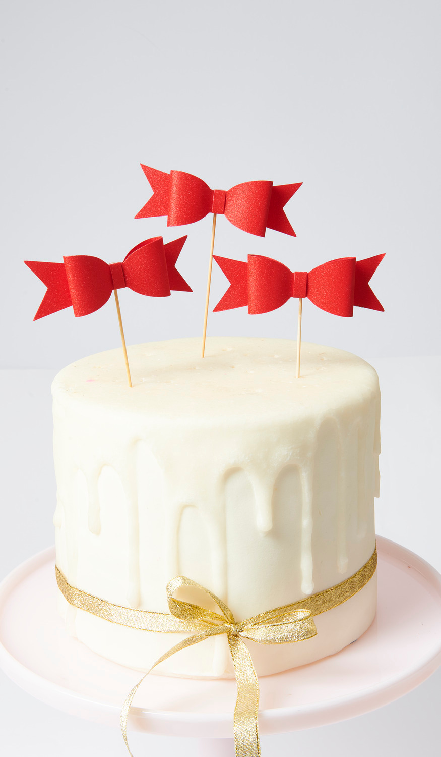 Picker Schleife Rot 10,5x13,5cm 6 Stück von Rico Design Picker Schleife Rot: Drei rote Schleifen-Picker auf einer weißen Torte mit goldener Schleife dekoriert.
