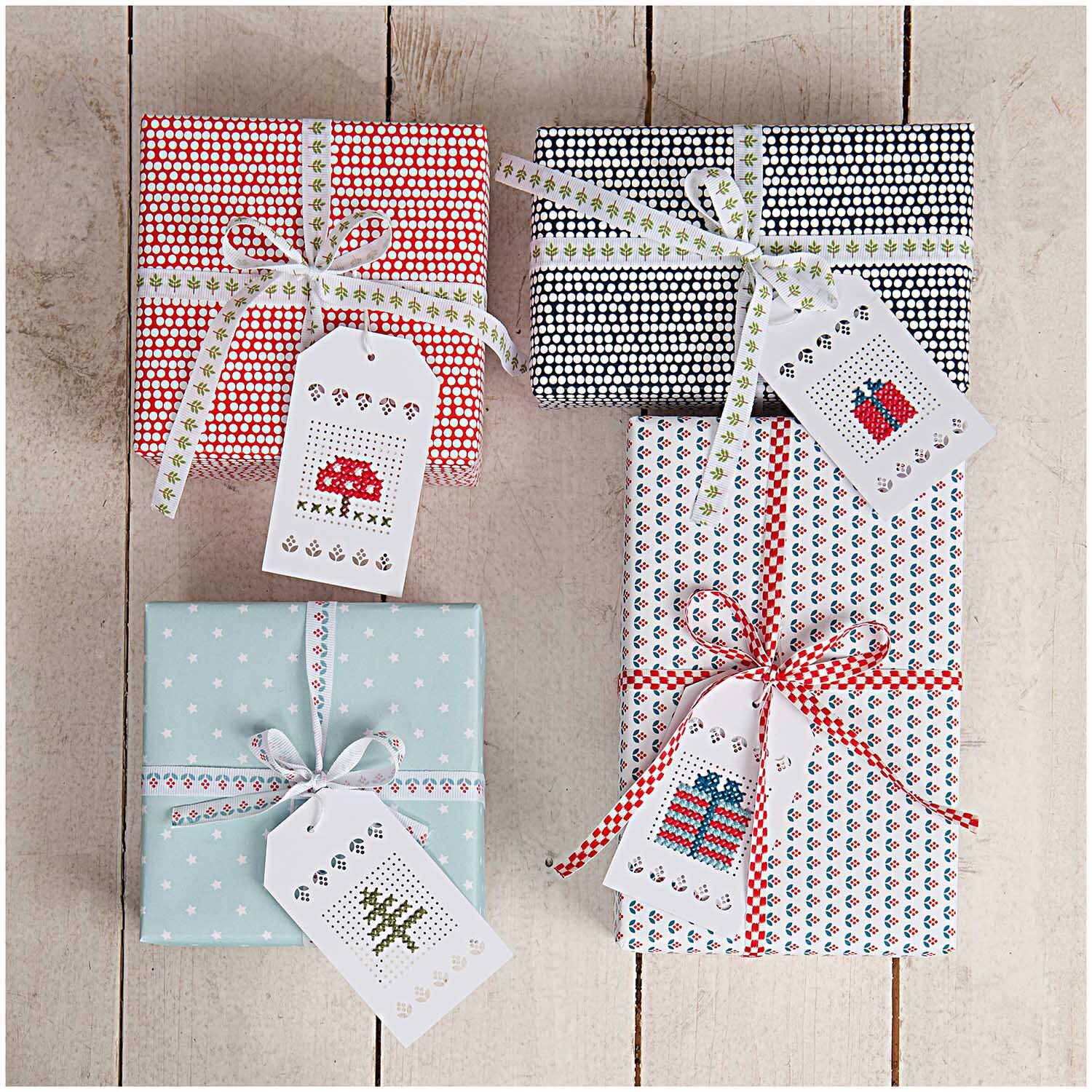 Anhänger zum Besticken creme 24 Stück von Rico Design Anhänger zum Besticken creme 24 Stück von Rico Design auf Geschenken mit verschiedenen Mustern und Schleifen.