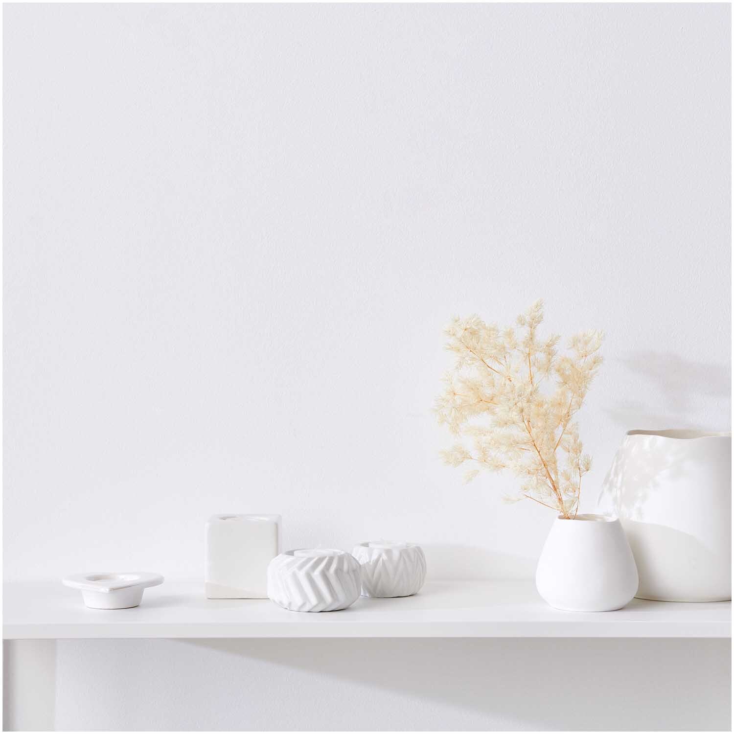 Porzellan-Teelichthalter in elegantem Design auf einem Regal, umgeben von minimalistischen Vasen. Ideal für stilvolle Dekoration.