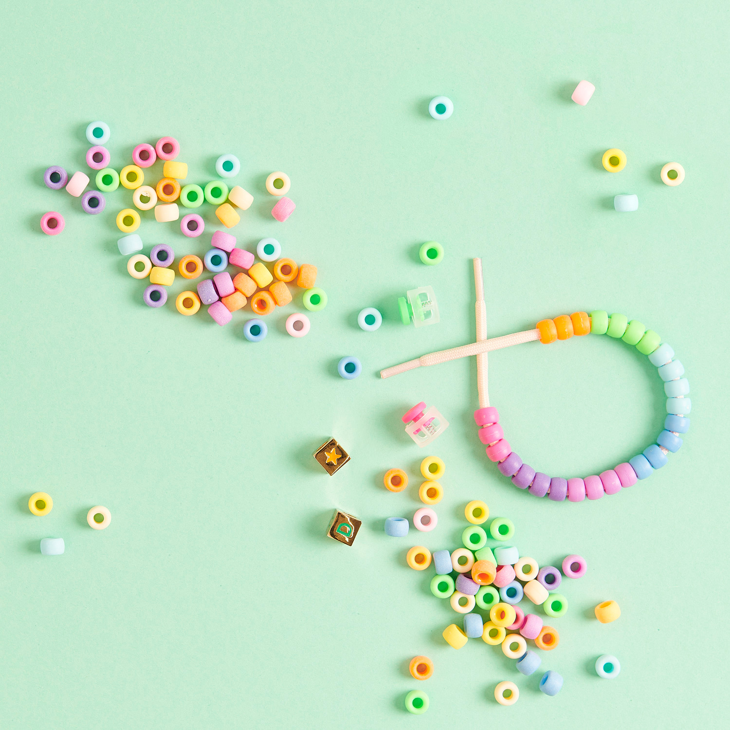 itoshii - Ponii Beads matt Regenbogen 9x6mm 400 Stück von Rico Design itoshii - Ponii Beads matt Regenbogen 9x6mm, bunte Perlen auf grünem Hintergrund, ideal für DIY-Schmuck.