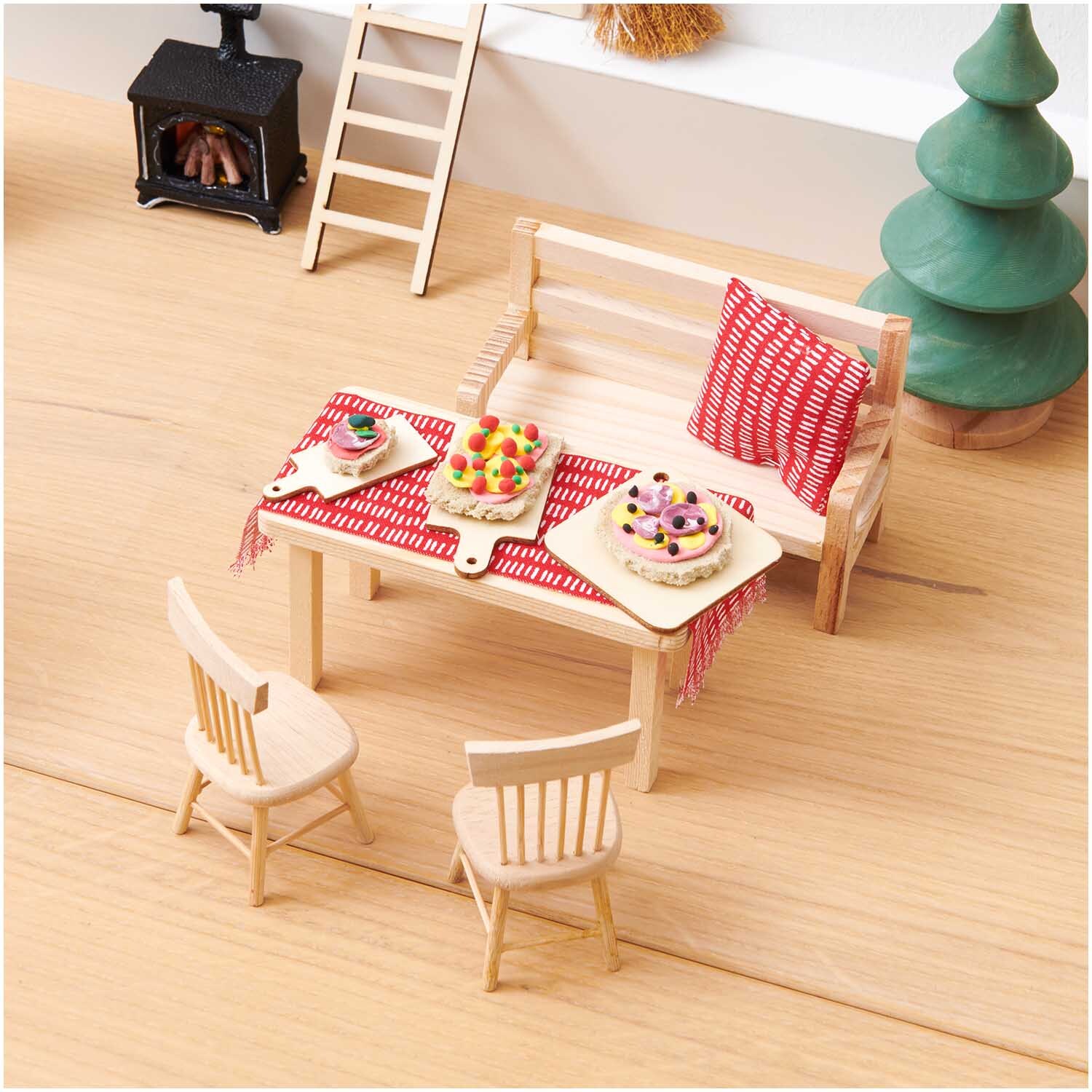 Miniatur Schneidebrettchen 5-teilig von Rico Design Miniatur Schneidebrettchen, 5-teilig, auf einem Tisch mit roten Tischdecken und Miniaturmöbeln.