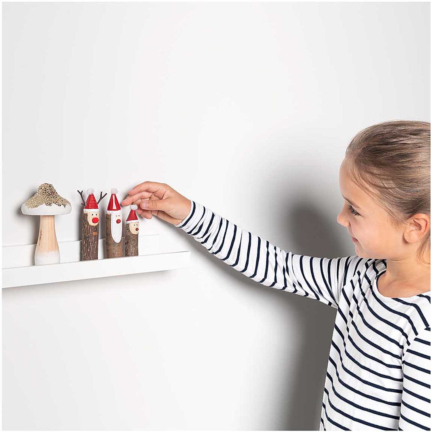 Holzfigur Rentier 7x12,5cm von Rico Design Holzfigur Rentier 7x12,5cm von Rico Design: Kind dekoriert ein Regal mit bunten Holzfiguren.