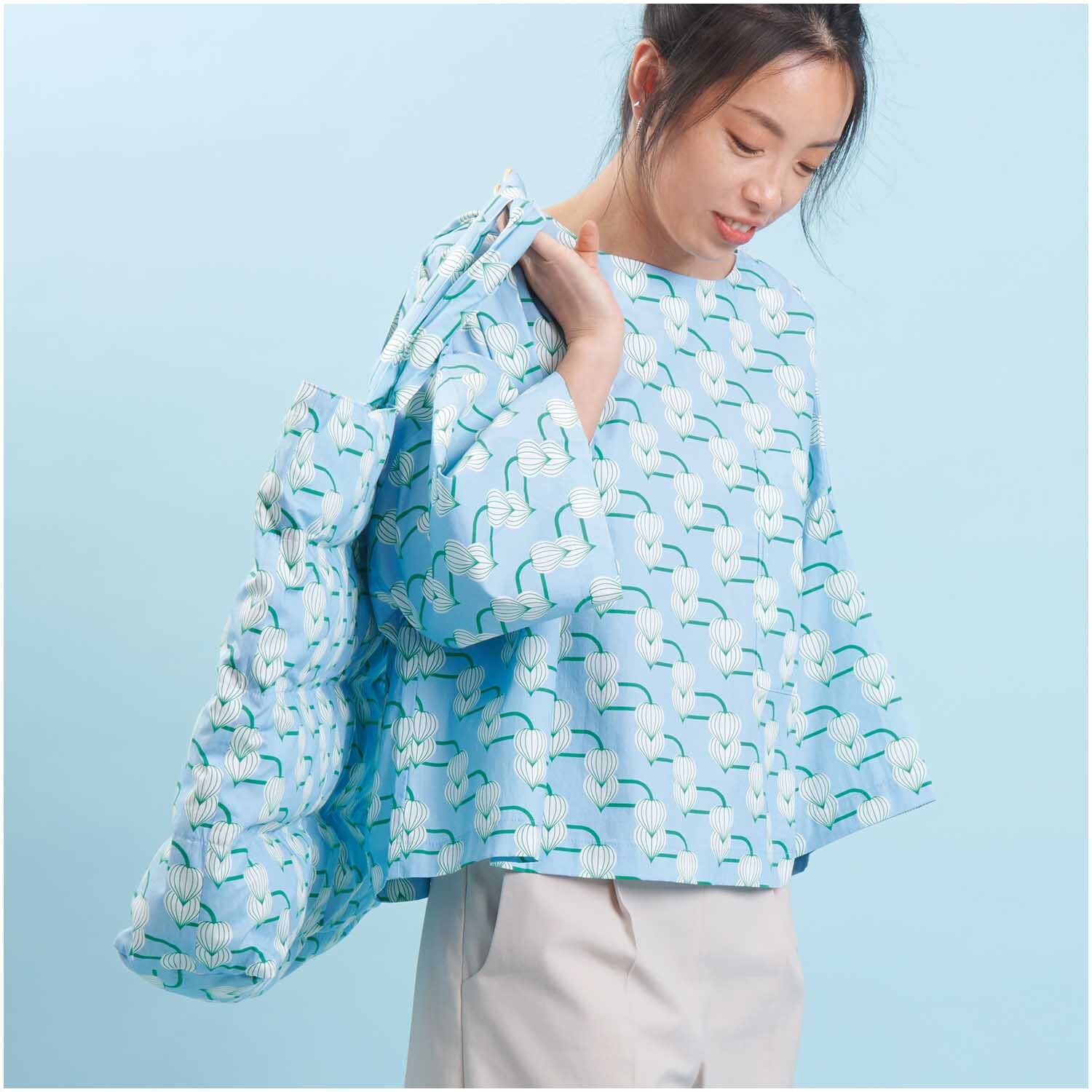 Meterware Baumwoll-Popelin blau Knospen von Rico Design Meterware Baumwoll-Popelin blau Knospen: Frau trägt ein Outfit aus gemustertem Stoff von Rico Design.