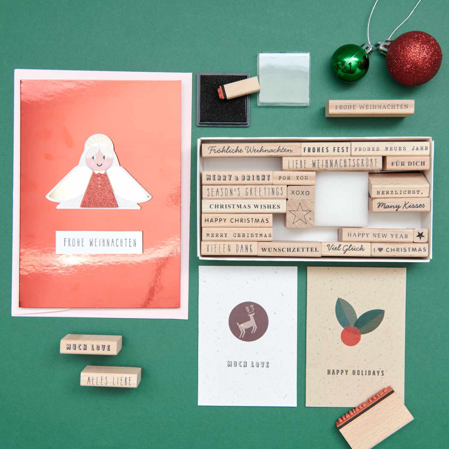Paper Poetry XL Stempelset Merry Christmas mixed type 27-teilig von Rico Design Paper Poetry XL Stempelset Merry Christmas mixed type, 27-teilig, auf grünem Hintergrund mit Weihnachtskarten und Dekoration.