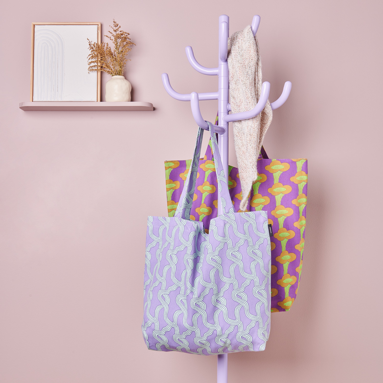 Canvas-Shopper Myzel Flieder 38x40x13cm von Rico Design Canvas-Shopper Pfifferlinge Neon Violett und Myzel Flieder hängen an einem pastellfarbenen Kleiderständer.